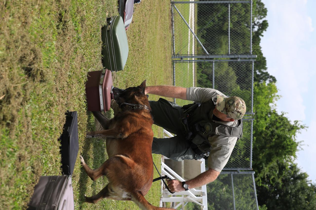 K-9 Handler Officer Scott O’Rourke watches as K-9 LJ selects the container with a suspicious substance during a training exercise on July 10, 2019, at Kennedy Space Center’s Protective Services Office in Florida. The center’s specially trained K-9s support the center 24/7, 365 days. Their main goal is to protect the Kennedy workforce and assets. Normal activities include sweeps of designated facilities, parking lots and random vehicle inspections at entrance gates. During rocket launches, they are out and about performing sweeps of facilities and launch site viewing areas. They cover Kennedy and the Merritt Island National Wildlife Refuge.