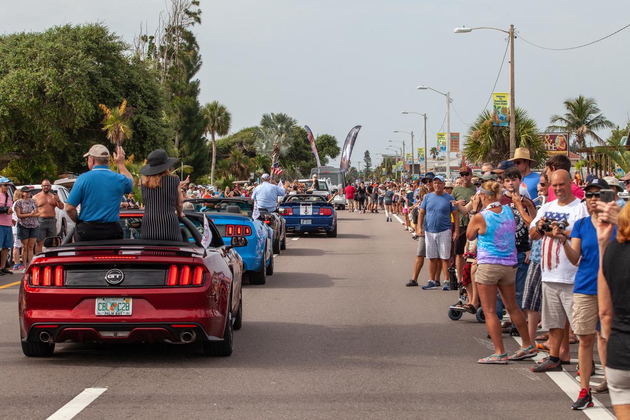Spectators watch as a lineup of Ford Mustangs carry retired shuttle astronauts and family members of Apollo astronauts during the "Man on the Moon" astronaut parade in Cocoa Beach, Floirida, on July 13, 2019. The parade was held to honor the 50th anniversary of NASA’s Saturn V/Apollo 11 launch and landing on the Moon.