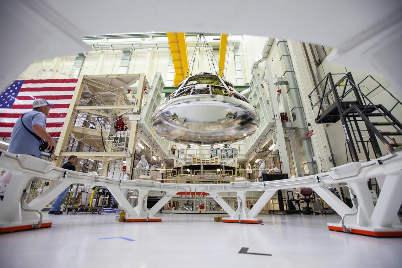 The Orion crew module for Artemis 1 is lifted by crane on July 16, 2019, in the high bay inside the Neil Armstrong Operations and Checkout Building high bay at NASA’s Kennedy Space Center in Florida. The crew module will be moved to the final assembly and test cell and work will begin to secure it atop the service module. The Orion spacecraft is being prepared for its uncrewed test flight atop NASA’s Space Launch System (SLS) rocket. Artemis 1 is the first test flight of the SLS and Orion spacecraft as an integrated system. Orion will travel thousands of miles beyond the Moon during a mission that will test its systems in space. The spacecraft will return to Earth and splashdown in the Pacific Ocean where it will be retrieved and transported back to Kennedy.
