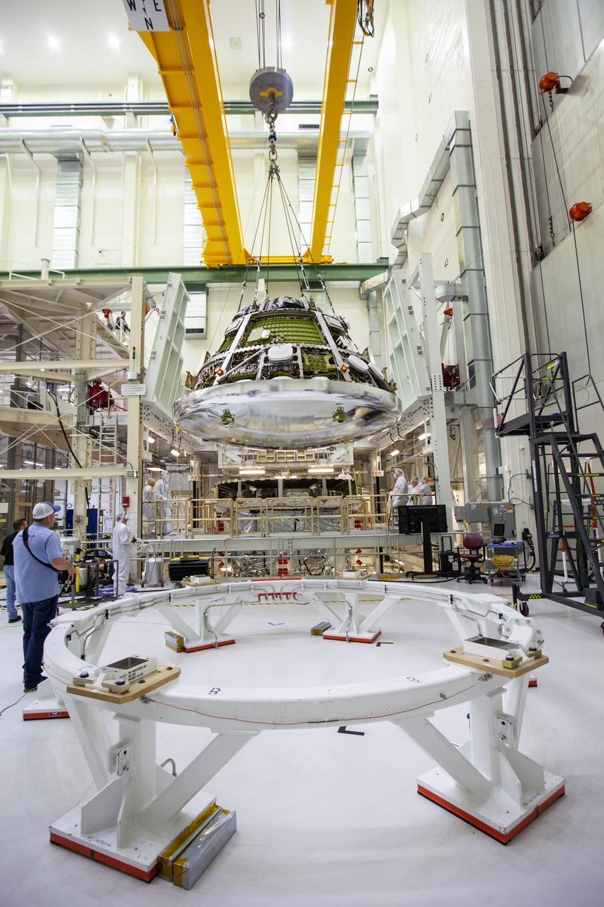The Orion crew module for Artemis 1 is lifted by crane on July 16, 2019, in the high bay inside the Neil Armstrong Operations and Checkout Building high bay at NASA’s Kennedy Space Center in Florida. The crew module is being moved to the final assembly and test cell and work will begin to secure it atop the service module. The Orion spacecraft is being prepared for its uncrewed test flight atop NASA’s Space Launch System (SLS) rocket. Artemis 1 is the first test flight of the SLS and Orion spacecraft as an integrated system. Orion will travel thousands of miles beyond the Moon during a mission that will test its systems in space. The spacecraft will return to Earth and splashdown in the Pacific Ocean where it will be retrieved and transported back to Kennedy.