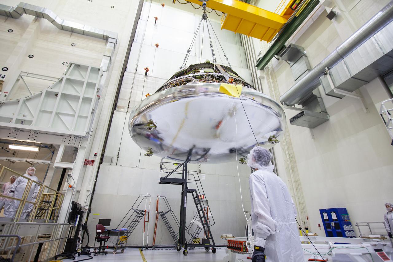 The Orion crew module for Artemis 1 is lifted by crane on July 16, 2019, in the high bay inside the Neil Armstrong Operations and Checkout Building high bay at NASA’s Kennedy Space Center in Florida. The crew module is being moved to the final assembly and test cell and work will begin to secure it atop the service module. The Orion spacecraft is being prepared for its uncrewed test flight atop NASA’s Space Launch System (SLS) rocket. Artemis 1 is the first test flight of the SLS and Orion spacecraft as an integrated system. Orion will travel thousands of miles beyond the Moon during a mission that will test its systems in space. The spacecraft will return to Earth and splashdown in the Pacific Ocean where it will be retrieved and transported back to Kennedy.