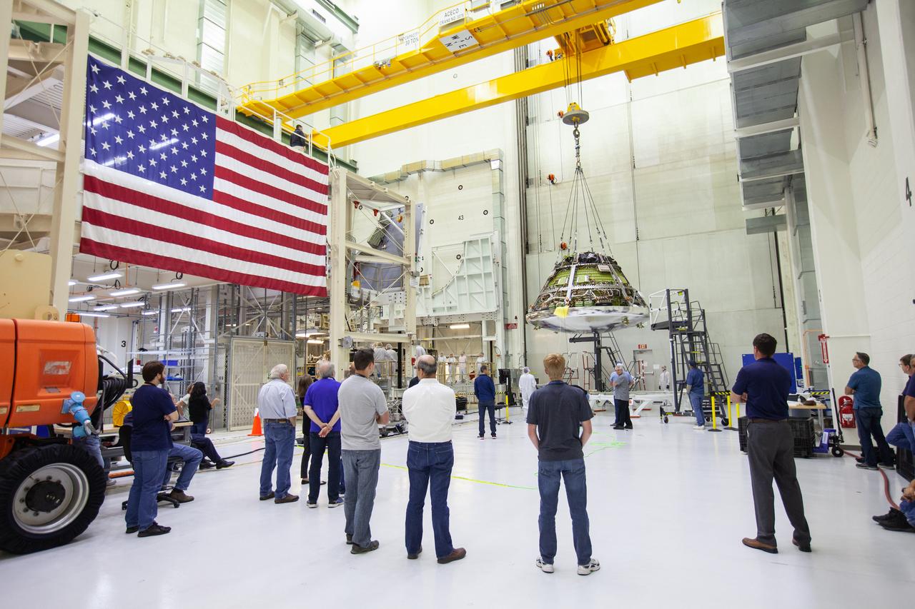 Engineers and technicians monitor the progress as the Orion crew module for Artemis 1 is moved by crane on July 16, 2019, in the high bay inside the Neil Armstrong Operations and Checkout Building high bay at NASA’s Kennedy Space Center in Florida. The crew module is being moved to the final assembly and test cell and work will begin to secure it atop the service module. The Orion spacecraft is being prepared for its uncrewed test flight atop NASA’s Space Launch System (SLS) rocket. Artemis 1 is the first test flight of the SLS and Orion spacecraft as an integrated system. Orion will travel thousands of miles beyond the Moon during a mission that will test its systems in space. The spacecraft will return to Earth and splashdown in the Pacific Ocean where it will be retrieved and transported back to Kennedy.