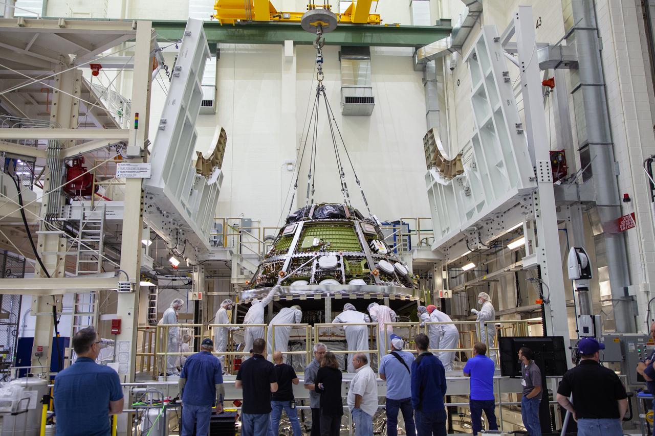 The Orion crew module for Artemis 1 is lowered by crane atop its service module on July 16, 2019, in the high bay inside the Neil Armstrong Operations and Checkout Building high bay at NASA’s Kennedy Space Center in Florida. Technicians begin the work to secure the crew module onto the service module in the final assembly and test cell. The Orion spacecraft is being prepared for its uncrewed test flight atop NASA’s Space Launch System (SLS) rocket. Artemis 1 is the first test flight of the SLS and Orion spacecraft as an integrated system. Orion will travel thousands of miles beyond the Moon during a mission that will test its systems in space and during re-entry. The spacecraft will return to Earth and splashdown in the Pacific Ocean where it will be retrieved and transported back to Kennedy.