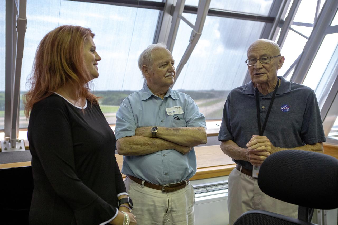 On July 16, 2019, the 50th anniversary of the Apollo 11 launch to the Moon; Apollo-era and Artemis launch team members mingle in Launch Control Center Firing Room 1 at NASA's Kennedy Space Center in Florida. From left, are Charlie Blackwell-Thompson, Artemis 1 launch director; Charlie Mars, Apollo 11 launch team member; and Bob Sieck, Apollo 11 launch team member and former space shuttle launch director.