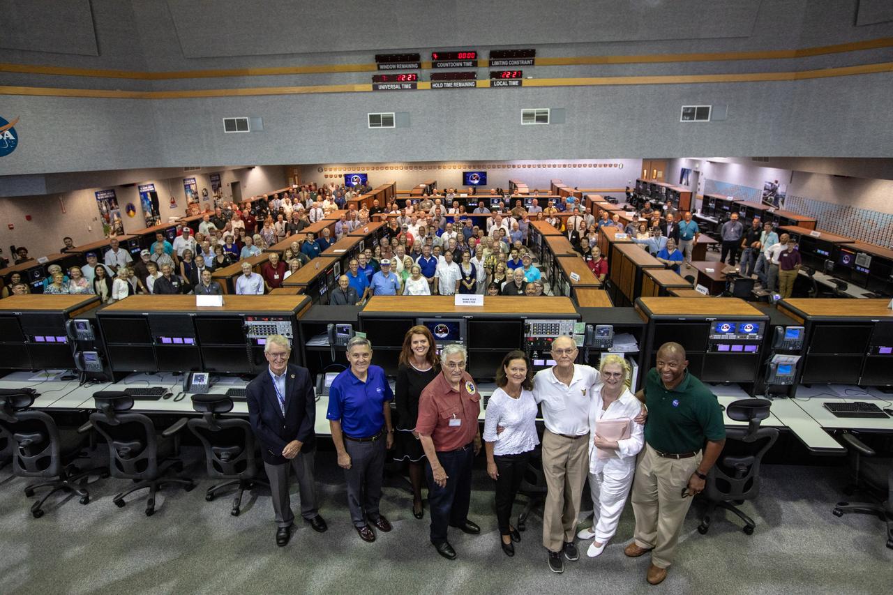 On July 16, 2019, the 50th anniversary of the Apollo 11 launch to the Moon, launch team members from Apollo 11 and Artemis 1 mingled in Launch Control Center Firing Room 1 at NASA's Kennedy Space Center in Florida. From left, are John Tribe, Apollo 11 launch team member; Kennedy Space Center Director Bob Cabana; Artemis 1 Launch Director Charlie Blackwell-Thompson; Harrison Schmitt, Apollo 17 astronaut; Apollo 11 astronaut Michael Collins, with his daughters Ann (left) and Kate (right); and Kelvin Manning, associate director, technical.