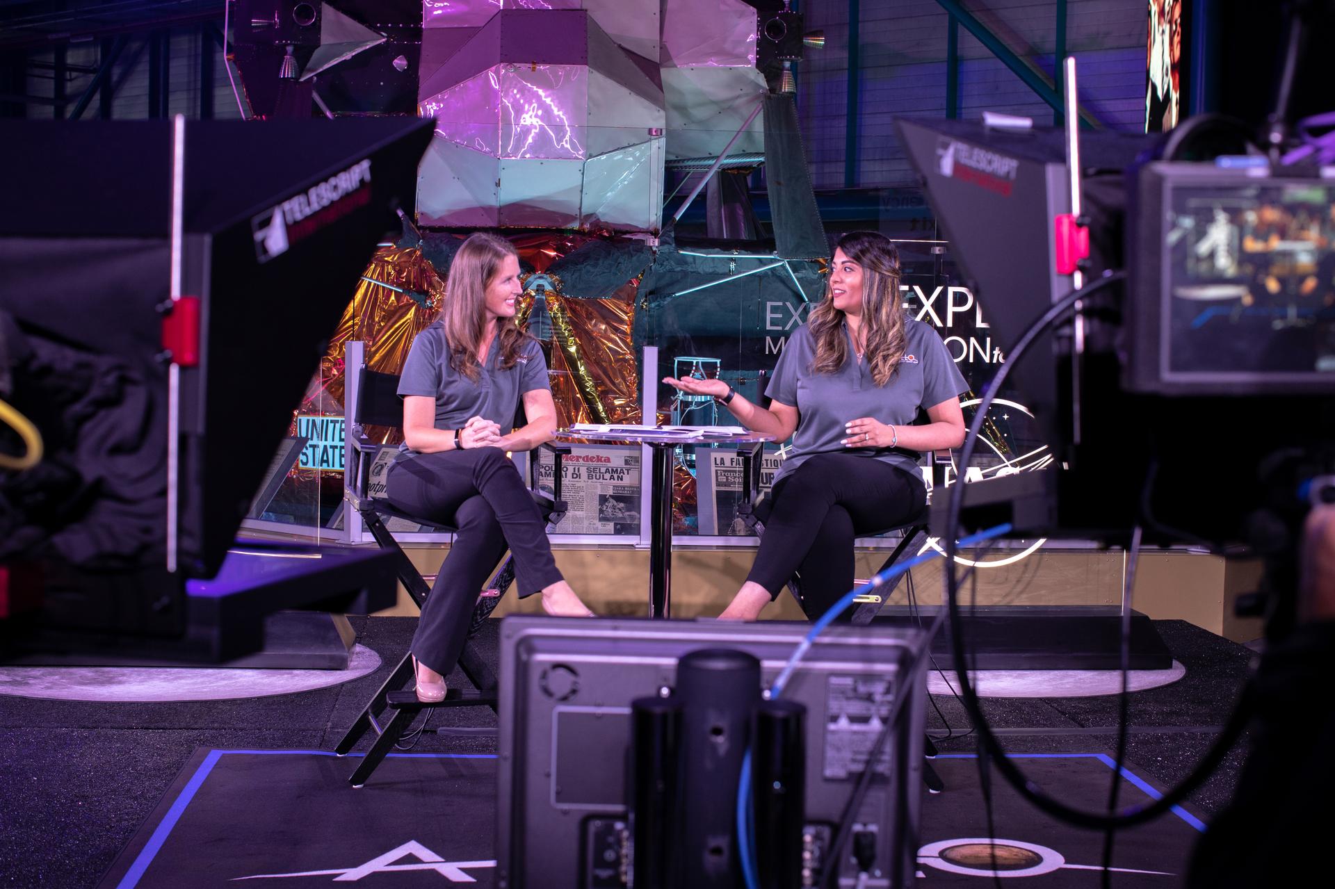 People on stage speaking to each other during a live broadcast