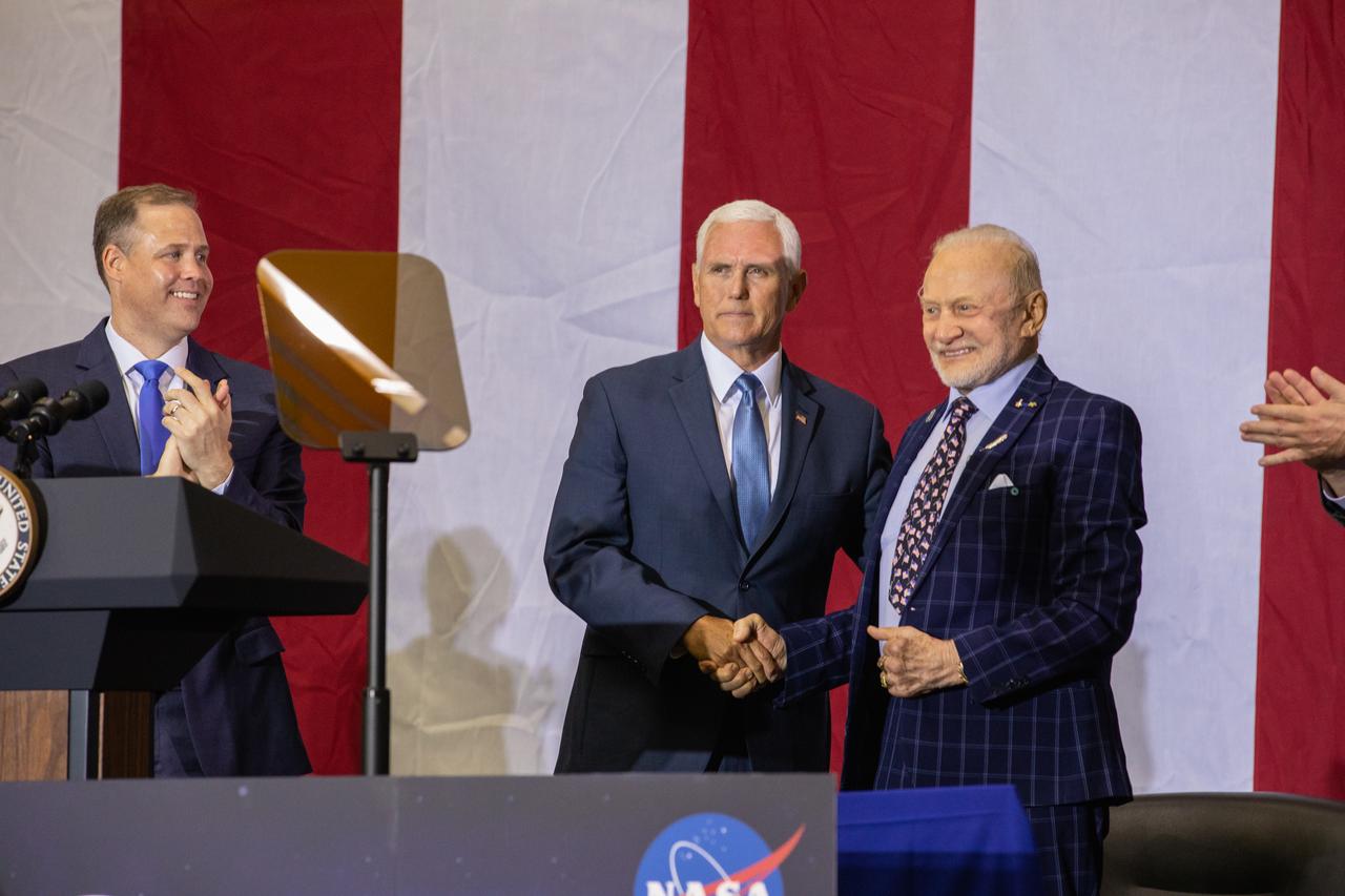 Vice President Mike Pence, center, addresses invited guests, elected officials and NASA, Lockheed Martin and other industry leaders at Kennedy Space Center’s Neil Armstrong Operations & Checkout Building on July 20, 2019. Pence, who visited the Florida spaceport in honor of the 50th anniversary of the Apollo 11 mission, also spoke about NASA’s progress and future plans to return to the Moon and on to Mars. At left is NASA Administrator Jim Bridenstine. At right is Apollo 11 Lunar Module Pilot Buzz Aldrin.