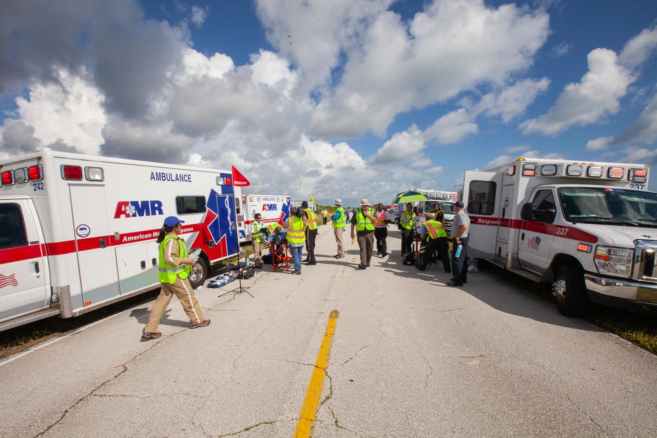 Medical and fire-rescue personnel park ambulances and set up a decontamination and triage area for a joint emergency escape and triage simulation held at Space Launch Complex 41 at Cape Canaveral Air Force Station in Florida on July 24, 2019.  Led by NASA with Boeing and United Launch Alliance, the simulation is one in a series in preparation for upcoming crew flights to the International Space Station as part of NASA’s Commercial Crew Program.  NASA astronauts Josh Cassada, currently in training for the second flight with crew aboard Boeing’s CST-100 Starliner spacecraft, and Eric Boe, along with astronaut candidate Jasmin Moghbeli, served as the flight crew. The astronauts practiced emergency egress from the nearly 200-foot-tall crew access tower at the launch pad. They also rehearsed escape from the launch complex in an armored vehicle, and decontamination and triage at a nearby helipad.