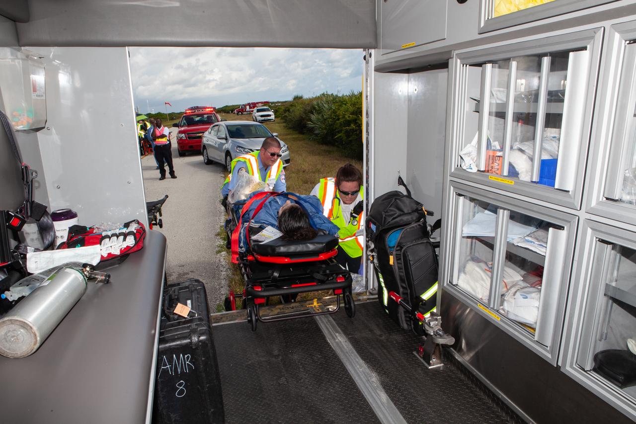 An astronaut with a simulated injury is loaded into an ambulance during a joint emergency escape and triage exercise led by NASA, along with Boeing and United Launch Alliance, at Space Launch Complex 41 at Cape Canaveral Air Force Station in Florida on July 24, 2019. The simulation is one in a series in preparation for upcoming crew flights to the International Space Station as part of NASA’s Commercial Crew Program.  NASA astronauts Josh Cassada, currently in training for the second flight with crew aboard Boeing’s CST-100 Starliner spacecraft, and Eric Boe, along with astronaut candidate Jasmin Moghbeli, served as the flight crew. The astronauts practiced emergency egress from the nearly 200-foot-tall crew access tower at the launch pad. They also rehearsed escape from the launch complex in an armored vehicle, and decontamination and triage at a nearby helipad.
