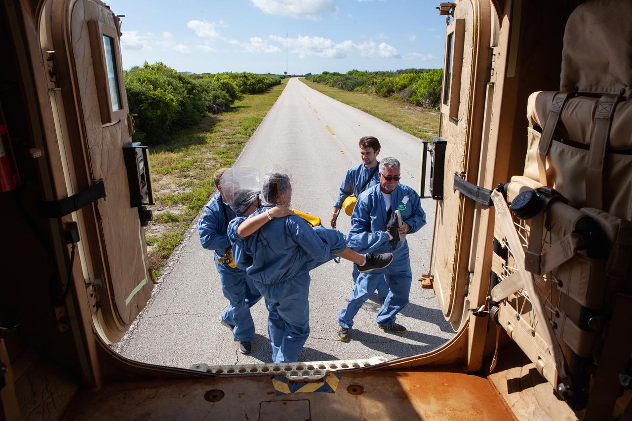 Astronauts with simulated injuries climb out of an armored vehicle during a joint emergency escape and triage simulation led by NASA, along with Boeing and United Launch Alliance, at Space Launch Complex 41 at Cape Canaveral Air Force Station in Florida on July 24, 2019. The simulation is one in a series in preparation for upcoming crew flights to the International Space Station as part of NASA’s Commercial Crew Program.  NASA astronauts Josh Cassada, currently in training for the second flight with crew aboard Boeing’s CST-100 Starliner spacecraft, and Eric Boe, along with astronaut candidate Jasmin Moghbeli, served as the flight crew. The astronauts practiced emergency egress from the nearly 200-foot-tall crew access tower at the launch pad. They also rehearsed escape from the launch complex in an armored vehicle, and decontamination and triage at a nearby helipad. 