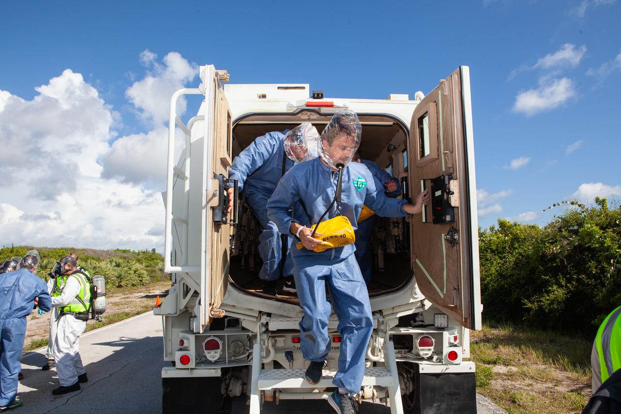 Wearing portable respirators, astronauts and personnel with simulated injuries exit an armored vehicle during a joint emergency escape and triage simulation led by NASA, along with Boeing and United Launch Alliance, at Space Launch Complex 41 at Cape Canaveral Air Force Station in Florida on July 24, 2019. The simulation is one in a series in preparation for upcoming crew flights to the International Space Station as part of NASA’s Commercial Crew Program.  NASA astronauts Josh Cassada, currently in training for the second flight with crew aboard Boeing’s CST-100 Starliner spacecraft, and Eric Boe, along with astronaut candidate Jasmin Moghbeli, served as the flight crew. The astronauts practiced emergency egress from the nearly 200-foot-tall crew access tower at the launch pad. They also rehearsed escape from the launch complex in an armored vehicle, and decontamination and triage at a nearby helipad.