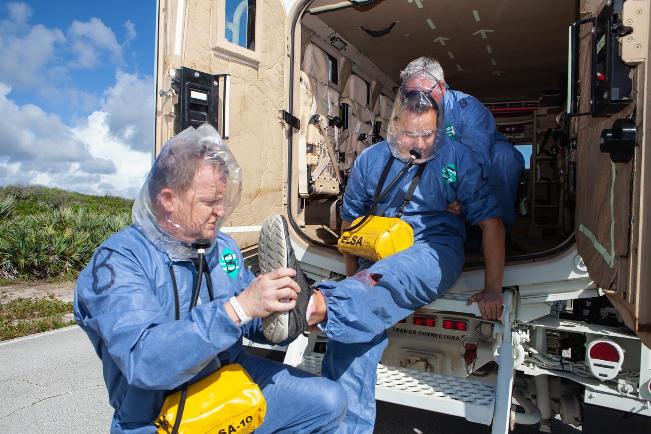 Wearing portable respirators, NASA astronauts Eric Boe, left, and Josh Cassada, participate in a joint emergency escape and triage simulation led by NASA, along with Boeing and United Launch Alliance, at Space Launch Complex 41 at Cape Canaveral Air Force Station in Florida on July 24, 2019. The simulation is one in a series in preparation for upcoming crew flights to the International Space Station as part of NASA’s Commercial Crew Program.  Boe, Cassada and astronaut candidate Jasmin Moghbeli served as the flight crew. Cassada is currently in training for the second flight with crew aboard Boeing’s CST-100 Starliner spacecraft. The astronauts practiced emergency egress from the nearly 200-foot-tall crew access tower at the launch pad. They also rehearsed escape from the launch complex in an armored vehicle, and decontamination and triage at a nearby helipad.