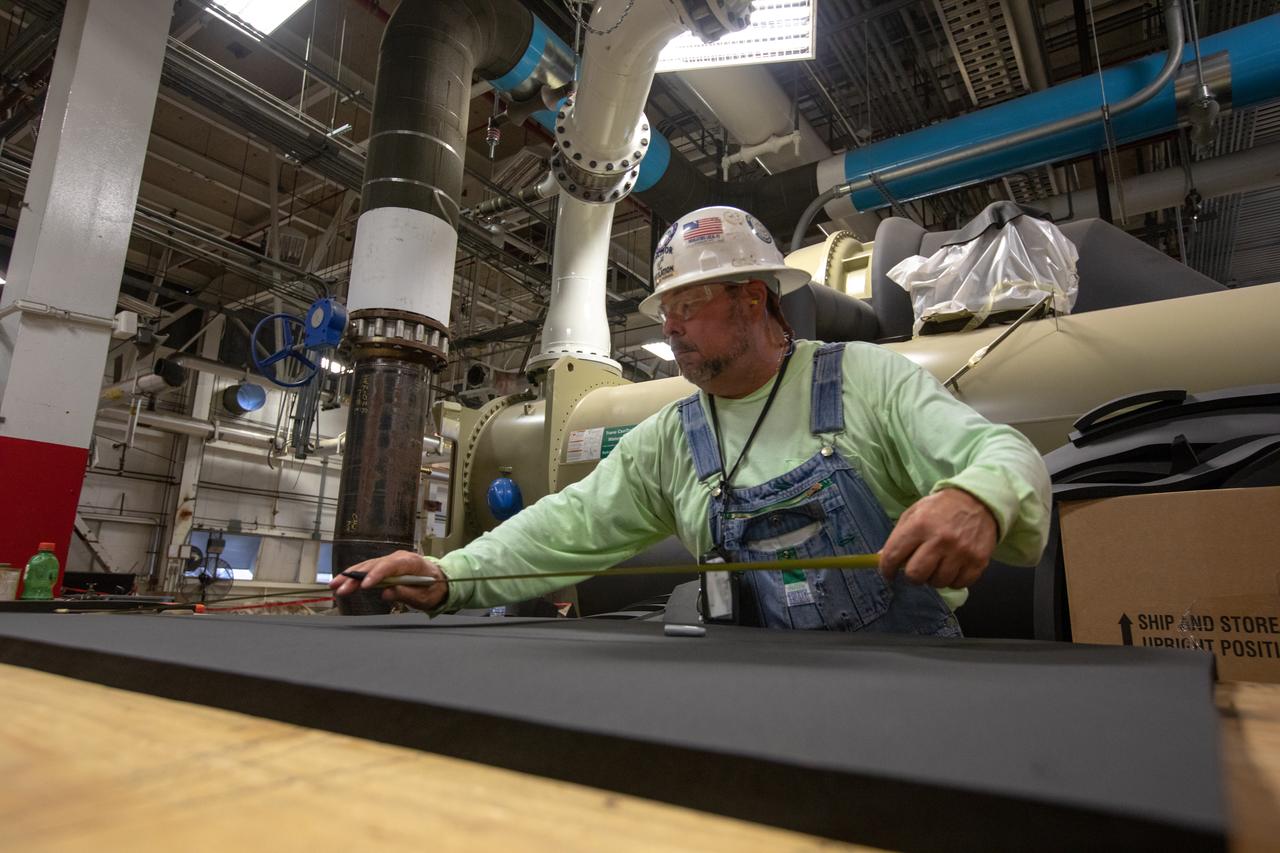 A technician measures foam insulation inside the Utility Annex near the Vehicle Assembly (VAB) Building at NASA’s Kennedy Space Center in Florida on July 24, 2019. The Utility Annex, which provides 8,000 gallons of chilled water per minute to the VAB and other facilities in the Launch Complex 39 area, is being upgraded and repaired. The facility also contains boilers necessary to provide hot water to the VAB. The center’s Engineering Directorate is making the repairs and upgrades to the facility to prepare for the agency’s Artemis missions to the Moon and on to Mars.