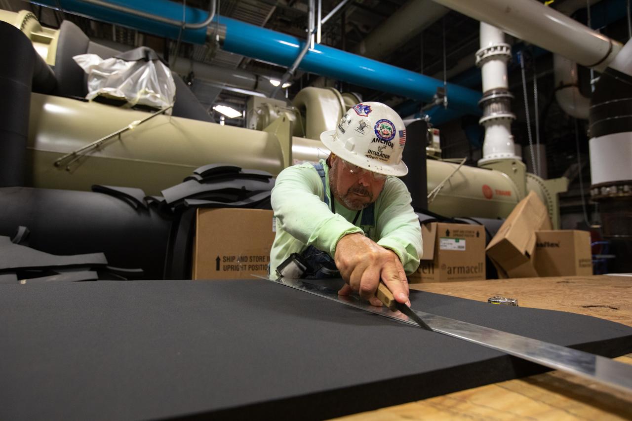 A technician cuts a section of foam insulation inside the Utility Annex near the Vehicle Assembly (VAB) Building at NASA’s Kennedy Space Center in Florida on July 24, 2019. The Utility Annex, which provides 8,000 gallons of chilled water per minute to the VAB and other facilities in the Launch Complex 39 area, is being upgraded and repaired. The facility also contains boilers necessary to provide hot water to the VAB. The center’s Engineering Directorate is making the repairs and upgrades to the facility to prepare for the agency’s Artemis missions to the Moon and on to Mars.
