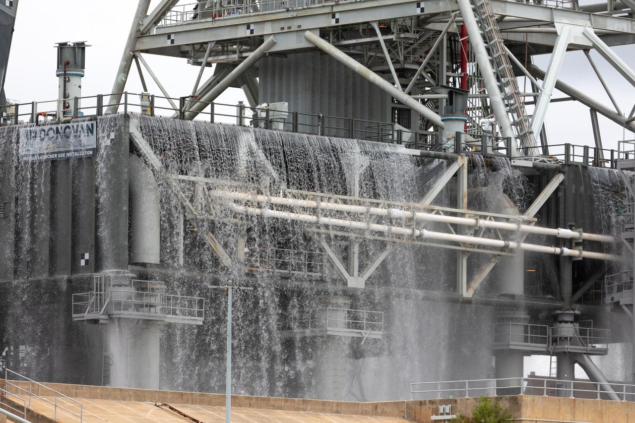 A flow test of the Ignition Overpressure Protection and Sound Suppression water deluge system is underway on the mobile launcher at Launch Pad 39B at NASA's Kennedy Space Center in Florida, on July 25, 2019. The testing is part of a series of tests that Exploration Ground System is doing to verify the system is ready for the new Space Launch System rocket. Modifications were made to the pad after a previous wet flow test, increasing the performance of the system. During the launch of Artemis 1 and subsequent missions, this water deluge system will release about 450,000 gallons of water across the mobile launcher and Flame Deflector to reduce the extreme heat and energy generated by the rocket during ignition and liftoff.