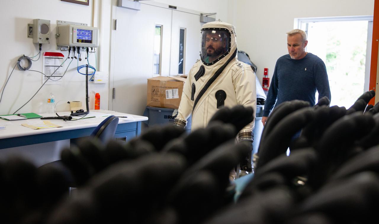 Inside the Multi-Operations Support Building near the Multi-Payload Processing Facility (MPPF) at NASA’s Kennedy Space Center in Florida, a technician is wearing a Self-Contained Atmospheric Protective Ensemble (SCAPE) suit to prepare for a test simulation of loading propellants into a replicated test tank for Orion, on Aug. 16, 2019. Exploration Ground Systems is preparing for Artemis 1 with a series of hazardous hyper test events at the MPPF. After donning their suits, the technicians will complete a tanking to test the system before Orion arrives for processing. During preparations for launch, these teams will be responsible for loading the Orion vehicle with propellants prior to transportation to the Vehicle Assembly Building, where it will be secured atop the Space Launch System rocket. SCAPE suits are used in operations involving toxic propellants and are supplied with air either through a hardline or through a self-contained environmental control unit.