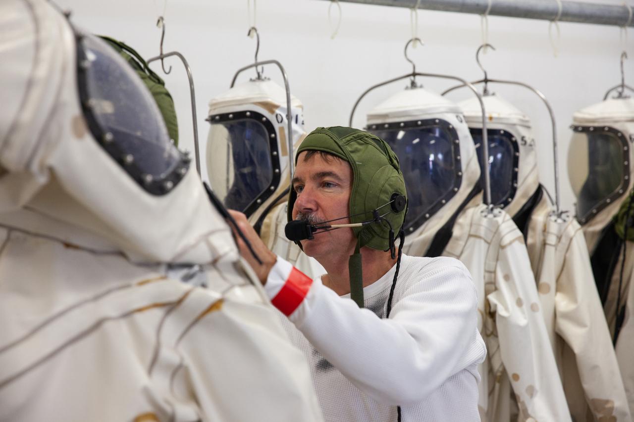 Inside the Multi-Operations Support Building near the Multi-Payload Processing Facility (MPPF) at NASA’s Kennedy Space Center in Florida, a technician prepares to put on a Self-Contained Atmospheric Protective Ensemble (SCAPE) suit inside a changing room on Aug. 16, 2019. SCAPE technicians are practicing putting on their suits for a test simulation of loading propellants into a replicated test tank for Orion. Exploration Ground Systems is preparing for Artemis 1 with a series of hazardous hyper test events at the MPPF. After donning their suits, the technicians will complete a tanking to test the system before Orion arrives for processing. During preparations for launch, these teams will be responsible for loading the Orion vehicle with propellants prior to transportation to the Vehicle Assembly Building, where it will be secured atop the Space Launch System rocket. SCAPE suits are used in operations involving toxic propellants and are supplied with air either through a hardline or through a self-contained environmental control unit.