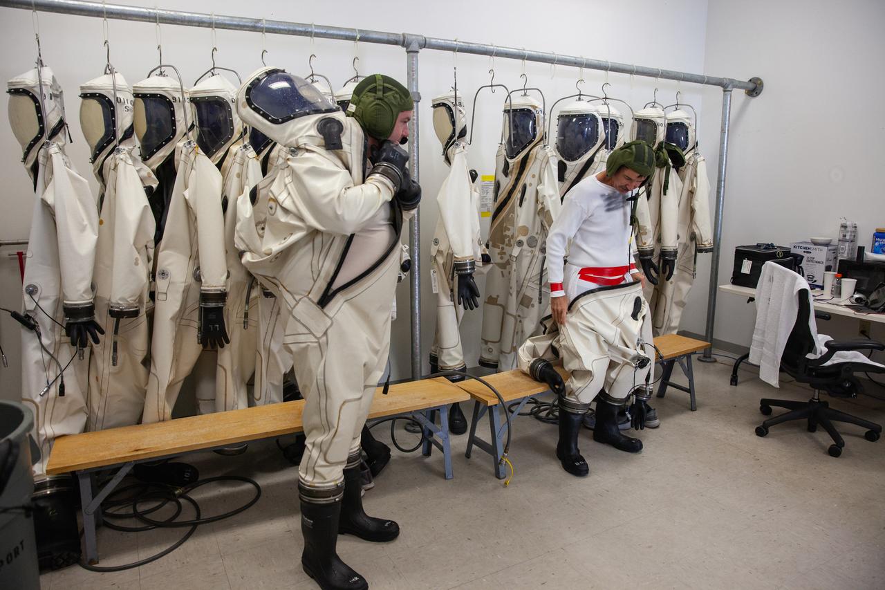 Inside the Multi-Operations Support Building near the Multi-Payload Processing Facility (MPPF) at NASA’s Kennedy Space Center in Florida, technicians put on Self-Contained Atmospheric Protective Ensemble (SCAPE) suits inside a changing room on Aug. 16, 2019. SCAPE technicians are practicing putting on the suits for a test simulation of loading propellants into a replicated test tank for Orion. Exploration Ground Systems is preparing for Artemis 1 with a series of hazardous hyper test events at the MPPF. After donning their suits, the technicians will complete a tanking to test the system before Orion arrives for processing. During preparations for launch, these teams will be responsible for loading the Orion vehicle with propellants prior to transportation to the Vehicle Assembly Building, where it will be secured atop the Space Launch System rocket. SCAPE suits are used in operations involving toxic propellants and are supplied with air either through a hardline or through a self-contained environmental control unit.