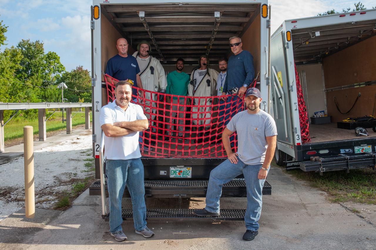 Technicians wearing Self-Contained Atmospheric Protective Ensemble (SCAPE) suits and operations support personnel prepare for a test simulation of loading propellants into a replicated test tank for Orion on Aug. 16, 2019, at NASA’s Kennedy Space Center in Florida. They are in a transport truck at the Multi-Operations Support Building near the Multi-Payload Processing Facility (MPPF). Exploration Ground Systems is preparing for Artemis 1 with a series of hazardous hyper test events at the MPPF. The technicians will complete a tanking to test the system before Orion arrives for processing. During preparations for launch, these teams will be responsible for loading the Orion vehicle with propellants prior to transportation to the Vehicle Assembly Building, where it will be secured atop the Space Launch System rocket. SCAPE suits are used in operations involving toxic propellants and are supplied with air either through a hardline or through a self-contained environmental control unit.