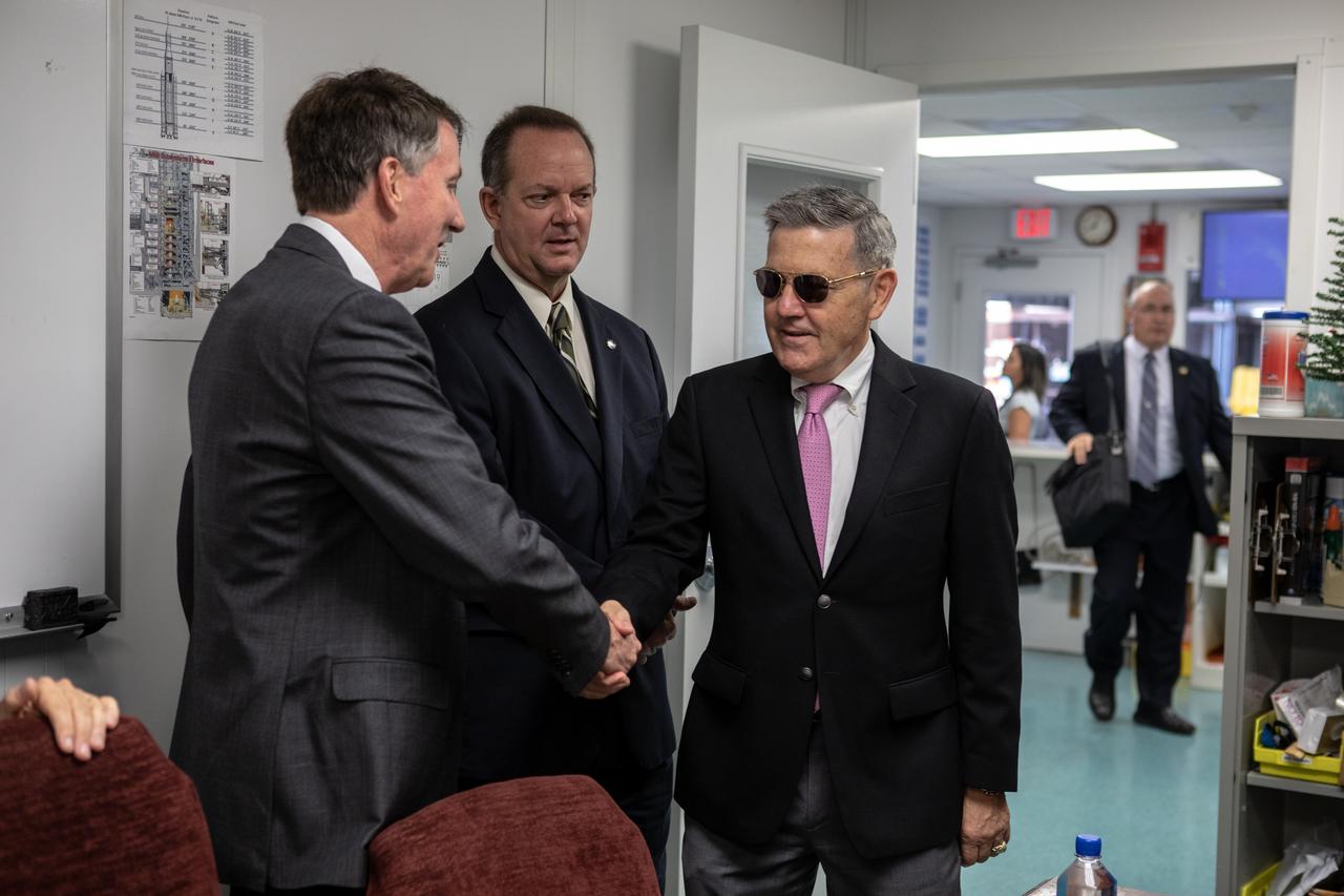 Just before a ribbon cutting ceremony on Aug. 16, 2019, in High Bay 2 of the Vehicle Assembly (VAB) at NASA’s Kennedy Space Center in Florida, Center Director Bob Cabana, at right, shakes hands with Kent Rominger, Northrop Grumman’s vice president and capture lead for the OmegA launch system. In the center is Tom Engler, director of the Center Planning and Development Office at Kennedy. The VAB is getting its first commercial tenant. Northrop Grumman signed a Reimbursable Space Act Agreement with NASA for use of the facilities. The company will assemble and test its new OmegA rocket inside the massive facility’s High Bay 2. The company also will modify the space shuttle-era mobile launcher platform-3 to serve as the launch vehicle’s assembly and launch platform. Northrop Grumman is developing the OmegA rocket, an intermediate/heavy-class launch vehicle, as part of a launch services agreement with the U.S. Air Force.