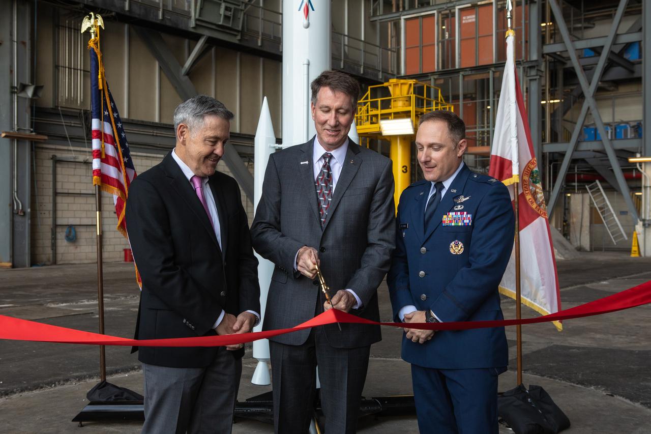 A ribbon cutting ceremony took place on Aug. 16, 2019, in High Bay 2 of the Vehicle Assembly Building (VAB) at NASA’s Kennedy Space Center in Florida. From left are Kennedy Center Director Bob Cabana; Kent Rominger, Northrop Grumman’s vice president and capture lead for the OmegA launch system; and Col. Thomas Ste. Marie, vice commander, U.S. Air Force, 45th Space Wing. Behind them is a scale model of the OmegA launch system. The VAB is getting its first commercial tenant. Northrop Grumman signed a Reimbursable Space Act Agreement with NASA for use of the facilities. The company will assemble and test its new OmegA rocket inside the massive facility’s High Bay 2. The company also will modify mobile launcher platform-3 to serve as the launch vehicle’s assembly and launch platform. Northrop Grumman is developing the OmegA rocket, an intermediate/heavy-class launch vehicle, as part of a launch services agreement with the U.S. Air Force.