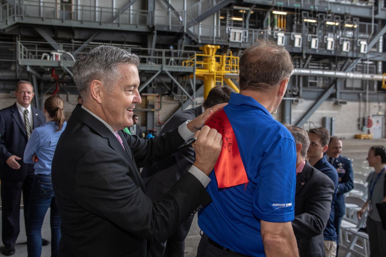 Legislators, invited guests and members of the media attend a ribbon cutting ceremony on Aug. 16, 2019, in High Bay 2 of the Vehicle Assembly Building (VAB) at NASA’s Kennedy Space Center in Florida. Kennedy Center Director Bob Cabana autographs a portion of the ribbon for a guest. In view, at far left, is Tom Engler, director of Kennedy’s Center Planning and Development Office. The VAB is getting its first commercial tenant. Northrop Grumman signed a Reimbursable Space Act Agreement with NASA for use of the facilities. The company will assemble and test its new OmegA rocket inside the massive facility’s High Bay 2. The company also will modify mobile launcher platform-3 to serve as the launch vehicle’s assembly and launch platform. Northrop Grumman is developing the OmegA rocket, an intermediate/heavy-class launch vehicle, as part of a launch services agreement with the U.S. Air Force.