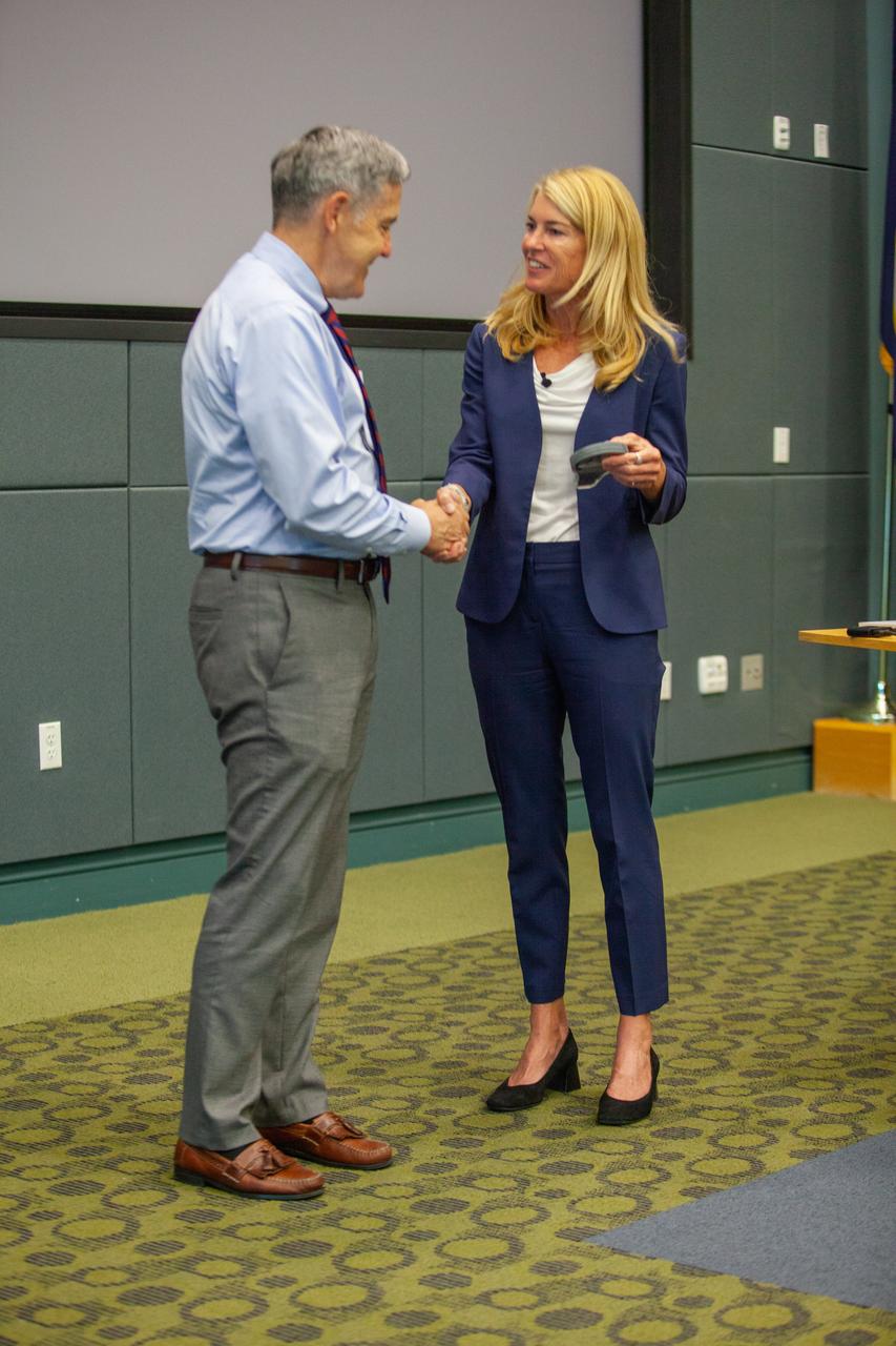 Kennedy Space Center Director Bob Cabana, left, presents well-known documentary filmmaker Robin Hauser with a token of appreciation during the “KSC and Proud to Be” centerwide diversity event held at the Florida spaceport’s Operations Support Building II (OSB II) on Aug. 20, 2019. The plaque was made from glass that was a part of Kennedy’s Launch Control Center during the Apollo and Space Shuttle programs. Hauser, who has spoken at the White House and at conferences worldwide, addressed bias in artificial intelligence. A new employee video focusing on the importance of employee resource groups at the center made its debut showing at the event.
