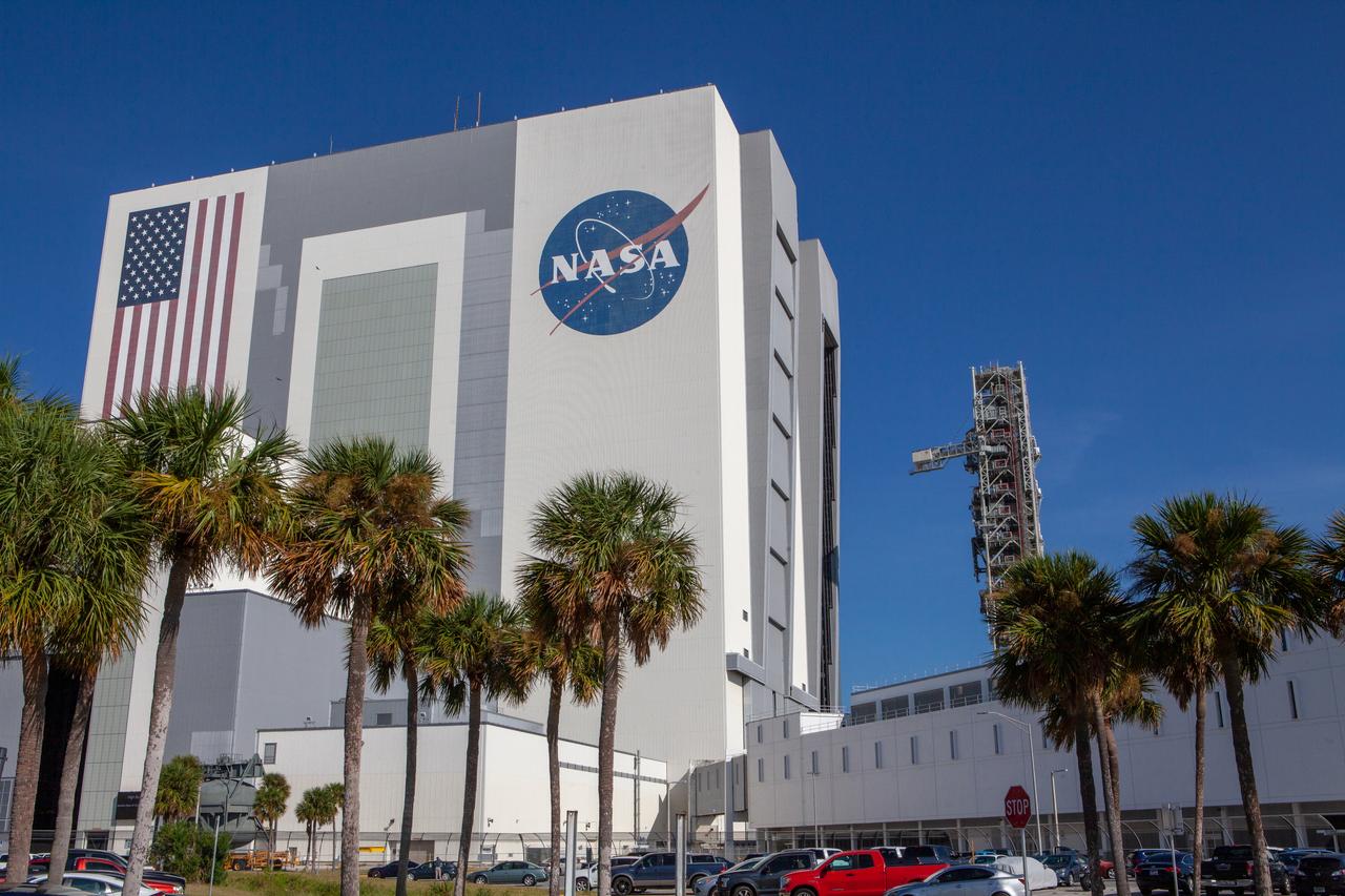 The mobile launcher for NASA’s Artemis missions rolls out of the Vehicle Assembly Building (VAB) and past the Launch Control Center at Kennedy Space Center in Florida on Sept. 10, 2019, after spending a week and a half inside due to the approach of Hurricane Dorian. The nearly 400-foot-tall structure was moved from Launch Pad 39B to the VAB for safekeeping on Aug. 30. The storm passed about 70 miles east of the spaceport during the overnight hours Tuesday, Sept. 3, and Wednesday, Sept. 4. NASA’s Exploration Ground Systems is moving the mobile launcher back to the launch pad, where teams will complete testing and checkout on the launcher in the coming weeks for the Artemis I mission.