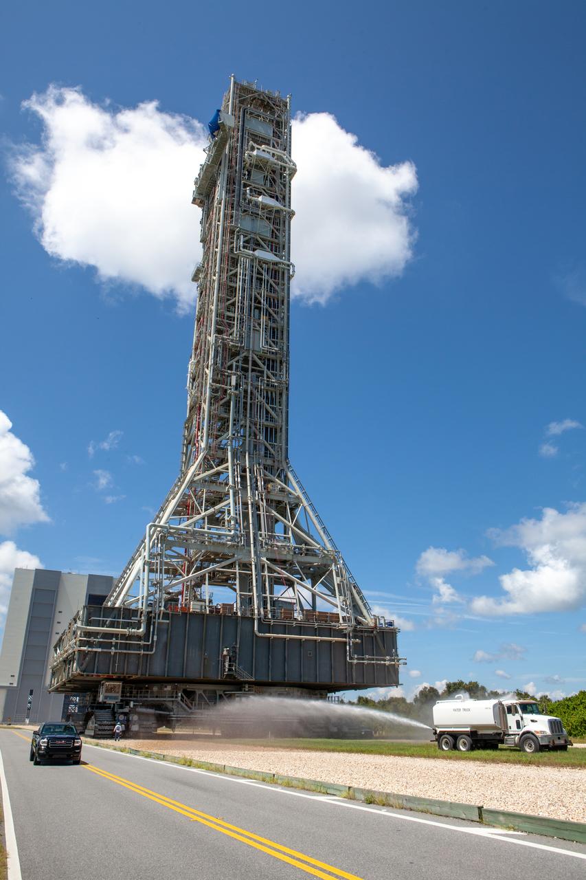 The mobile launcher for NASA’s Artemis missions moves along the crawlerway on Sept. 10, 2019, after spending a week and a half inside the Vehicle Assembly Building (VAB) at Kennedy Space Center in Florida due to the approach of Hurricane Dorian. The nearly 400-foot-tall structure was moved from Launch Pad 39B to the VAB for safekeeping on Aug. 30. The storm passed about 70 miles east of the spaceport during the overnight hours Tuesday, Sept. 3, and Wednesday, Sept. 4. NASA’s Exploration Ground Systems is moving the mobile launcher back to the launch pad, where teams will complete testing and checkout on the launcher in the coming weeks for the Artemis I mission.