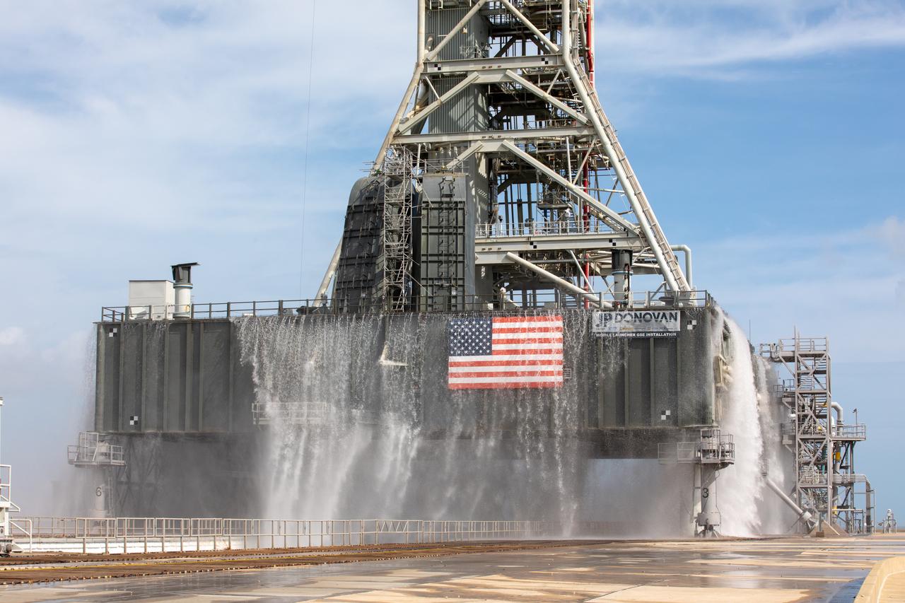 A wet flow test at Launch Pad 39B on September 13, 2019, tests the sound suppression system that will be used for launch of NASA’s Space Launch System for the Artemis I mission. During the test, about 450,000 gallons of water poured onto the Pad B flame deflector, the mobile launcher flame hole and onto the launcher’s blast deck. This was the first time the ground launch sequencer that will be used on the day of launch was used for the timing of a sound suppression test.