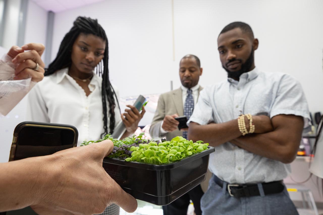 Langston University students Courtney Miller, left, and Sherman Cravens participate in a hands-on experience inside a Space Station Processing Facility lab at Kennedy Space Center on Sept. 18, 2019. Miller and Cravens were part of a tour of the Florida spaceport organized by Byron Quinn (background), Ph.D., Langston University director of the Science Research Institute, and NASA’s Office of Education. The Kennedy visit included stops at SwampWorks, the Neil Armstrong Operations and Checkout Building, the Vehicle Assembly Building, the visitor complex and the Center for Space Education.
