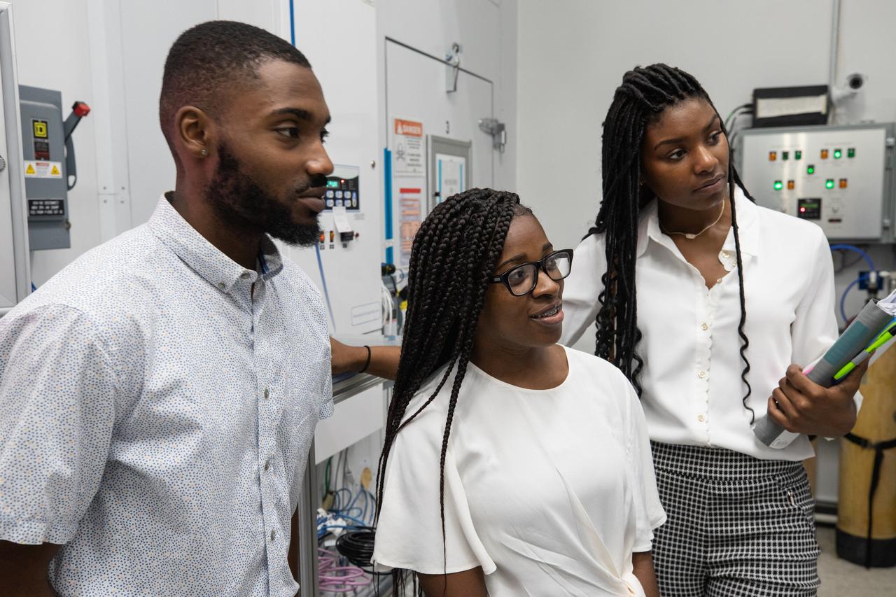 Langston University students, from left, Sherman Cravens, Makyah Farris and Courtney Miller listen to a presentation inside a Space Station Processing Facility lab at Kennedy Space Center on Sept. 18, 2019. The students were part of a tour of the Florida spaceport organized by NASA’s Office of Education and Byron Quinn, Ph.D., Langston University director of the Science Research Institute. The visit included stops at SwampWorks, the Neil Armstrong Operations and Checkout Building, the Vehicle Assembly Building, the visitor complex and the Center for Space Education.