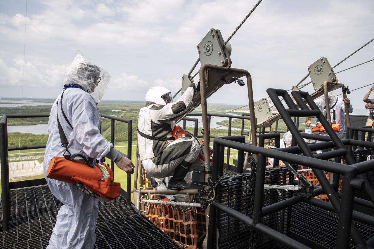 NASA and SpaceX conducted a formal verification of the company’s emergency escape system on Sept. 18, 2019, at Kennedy Space Center’s Launch Complex 39A in Florida. NASA astronauts Shannon Walker and Bob Behnken participated in the exercise to verify the crew can safely and quickly evacuate from the launch pad in the unlikely event of an emergency before liftoff of SpaceX’s first crewed flight test, called Demo-2. At tower level on the pad, Behnken practiced loading into a slidewire basket and simulating an emergency escape to ground level. As Boeing and SpaceX begin to make regular flights to the International Space Station for NASA’s Commercial Crew Program, the agency will continue to advance its mission to go beyond low-Earth orbit and establish a human presence on the Moon with the ultimate goal of sending astronauts to Mars.