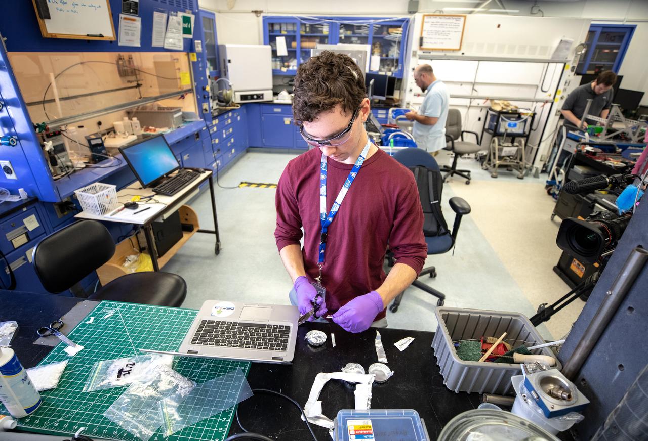 Patrick Follis, an intern at NASA’s Kennedy Space Center in Florida, cuts up different types of material for the agency’s Orbital Syngas Commodity Augmentation Reactor, or OSCAR, to use as a trash simulant during microgravity testing. OSCAR is an Early Career Initiative project at the spaceport that studies technology to convert trash and human waste into useful gasses such as methane, hydrogen and carbon dioxide. By processing small pieces of trash in a high-temperature reactor, OSCAR is advancing new and innovative technology for managing waste in space. OSCAR would reduce the amount of space needed for waste storage within a spacecraft, turn some waste into gasses that have energy storage and life support applications, and ensure waste is no longer biologically active. A prototype has been developed, and a team of Kennedy employees are in the process of constructing a new rig for suborbital flight testing.