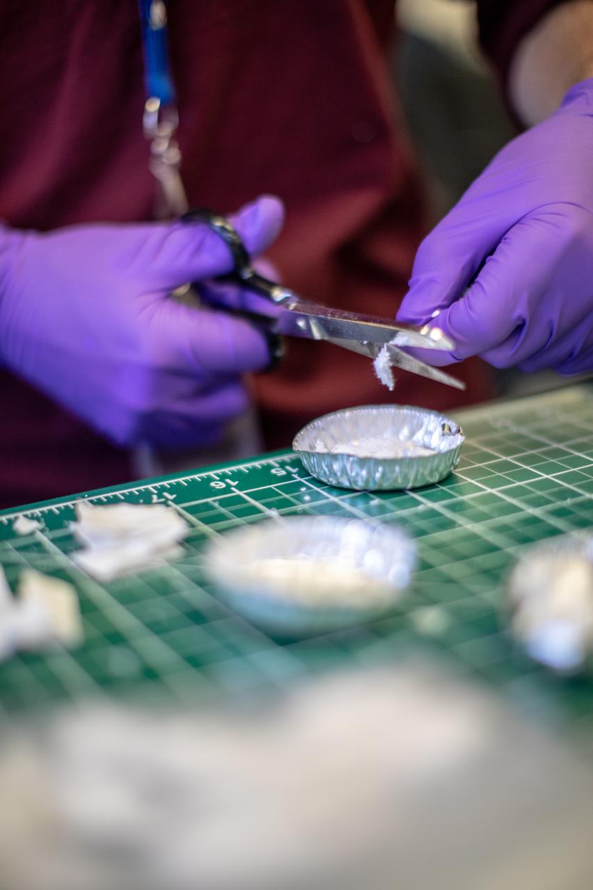 An intern at NASA’s Kennedy Space Center in Florida cuts up different types of material to be utilized as trash simulant for the agency’s Orbital Syngas Commodity Augmentation Reactor, or OSCAR. OSCAR is an Early Career Initiative project at the spaceport that studies technology to convert trash and human waste into useful gasses such as methane, hydrogen and carbon dioxide. By processing small pieces of trash in a high-temperature reactor, OSCAR is advancing new and innovative technology for managing waste in space. OSCAR would reduce the amount of space needed for waste storage within a spacecraft, turn some waste into gasses that have energy storage and life support applications, and ensure waste is no longer biologically active. A prototype has been developed, and a team of Kennedy employees are in the process of constructing a new rig for suborbital flight testing. 