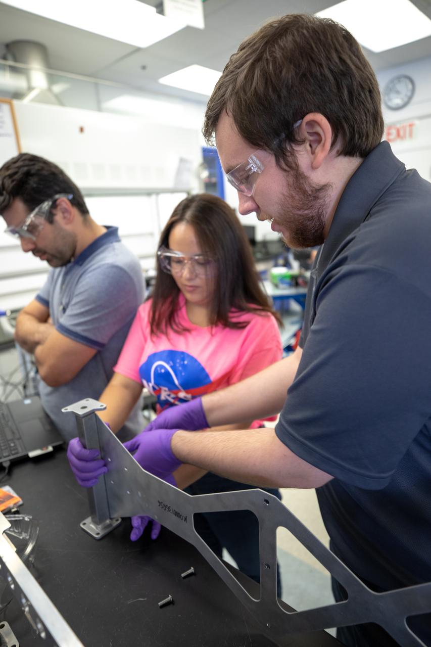 From left, Kennedy Space Center Mechanical Engineer Jaime Toro, NASA’s Orbital Syngas Commodity Augmentation Reactor (OSCAR) data acquisition and testing; Brianna Sandoval, OSCAR intern; and Jonathan Gleeson, Kennedy employee providing support for OSCAR under the center’s Laboratory Support Services and Operations contract, assemble the flight hardware of OSCAR. OSCAR is an Early Career Initiative project at the Florida spaceport that studies technology to convert trash and human waste into useful gasses such as methane, hydrogen and carbon dioxide. By processing small pieces of trash in a high-temperature reactor, OSCAR is advancing new and innovative technology for managing waste in space. OSCAR would reduce the amount of space needed for waste storage within a spacecraft, turn some waste into gasses that have energy storage and life support applications, and ensure waste is no longer biologically active. A prototype has been developed, and a team of Kennedy employees are in the process of constructing a new rig for suborbital flight testing. 