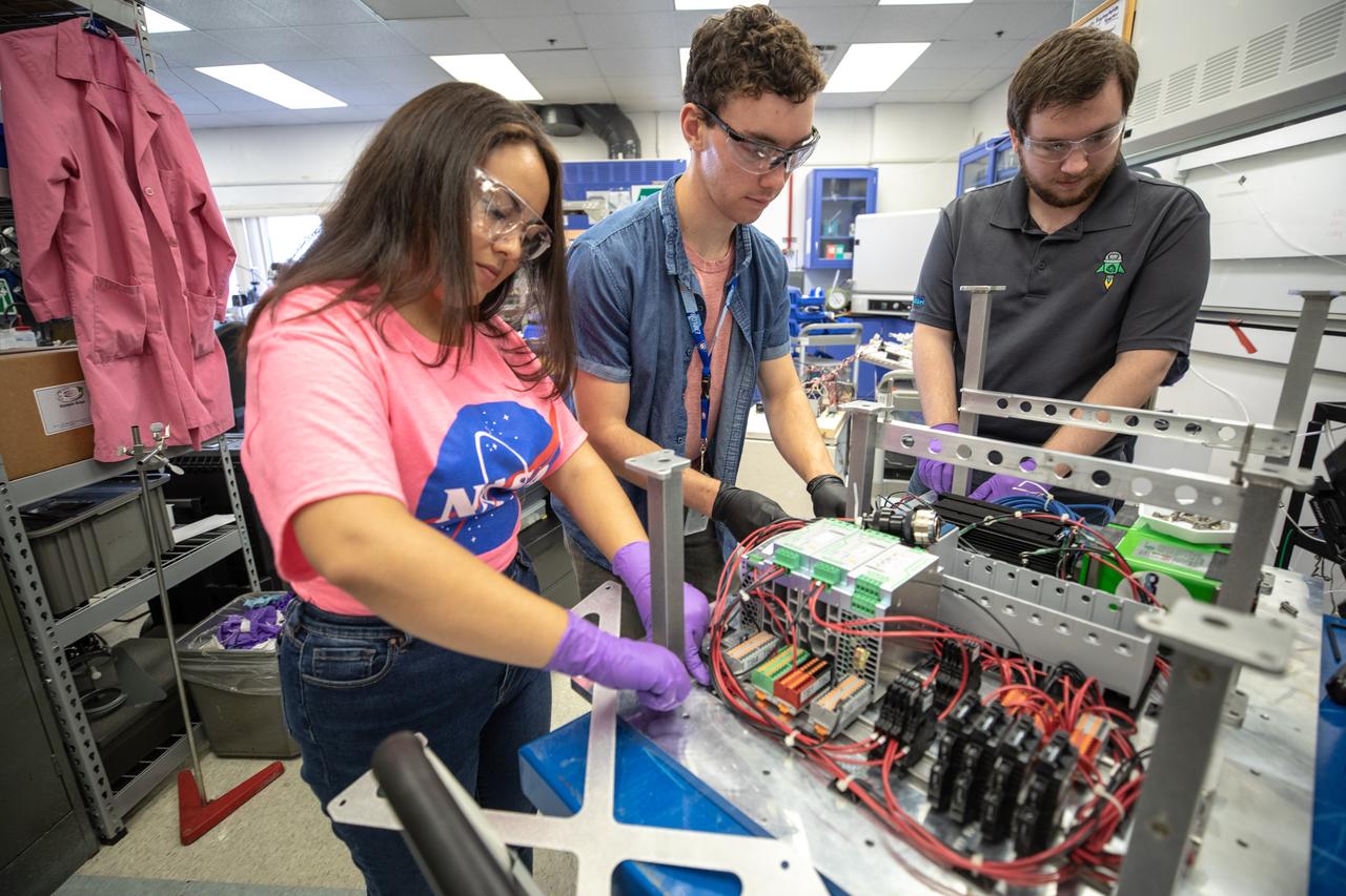 From left, Kennedy Space Center interns Brianna Sandoval and Patrick Follis, and Kennedy employee Jonathan Gleeson assemble the flight hardware of NASA’s Orbital Syngas Commodity Augmentation Reactor, or OSCAR. OSCAR is an Early Career Initiative project at the Florida spaceport that studies technology to convert trash and human waste into useful gasses such as methane, hydrogen and carbon dioxide. By processing small pieces of trash in a high-temperature reactor, OSCAR is advancing new and innovative technology for managing waste in space. OSCAR would reduce the amount of space needed for waste storage within a spacecraft, turn some waste into gasses that have energy storage and life support applications, and ensure waste is no longer biologically active. A prototype has been developed, and a team of Kennedy employees are in the process of constructing a new rig for suborbital flight testing. 