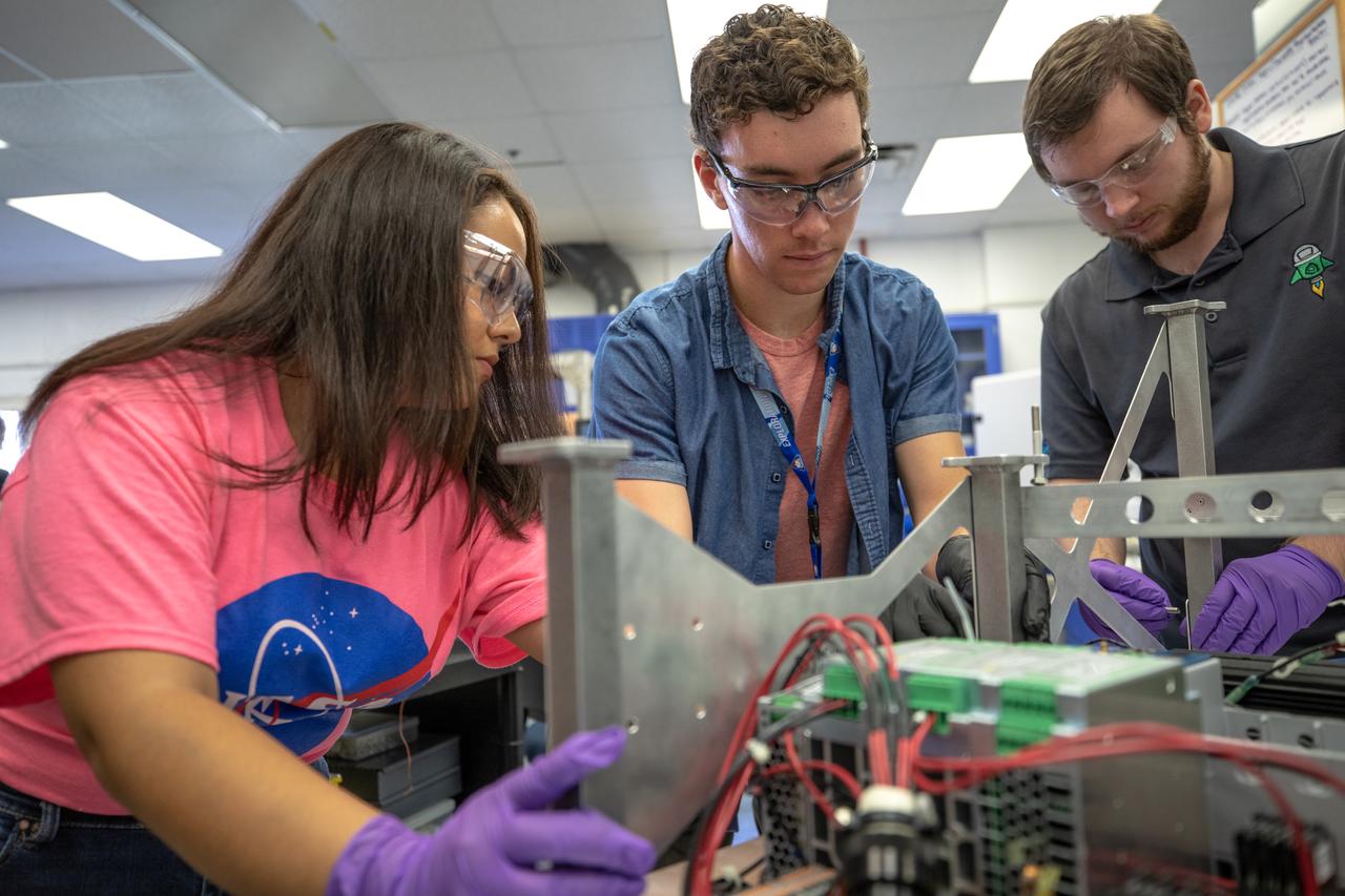 From left, Kennedy Space Center interns Brianna Sandoval and Patrick Follis, and Kennedy employee Jonathan Gleeson assemble the flight hardware of NASA’s Orbital Syngas Commodity Augmentation Reactor, or OSCAR. OSCAR is an Early Career Initiative project at the Florida spaceport that studies technology to convert trash and human waste into useful gasses such as methane, hydrogen and carbon dioxide. By processing small pieces of trash in a high-temperature reactor, OSCAR is advancing new and innovative technology for managing waste in space. OSCAR would reduce the amount of space needed for waste storage within a spacecraft, turn some waste into gasses that have energy storage and life support applications, and ensure waste is no longer biologically active. A prototype has been developed, and a team of Kennedy employees are in the process of constructing a new rig for suborbital flight testing. 