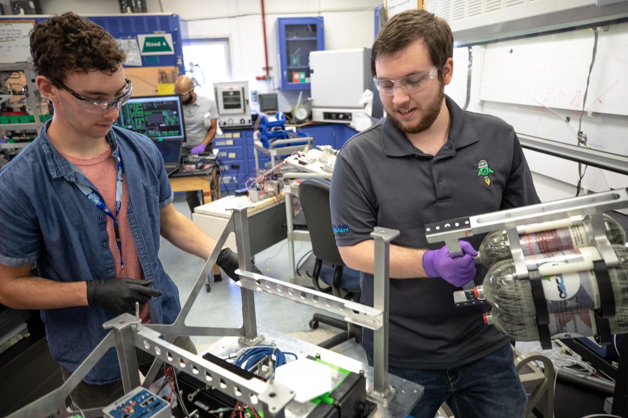 Kennedy Space Center employee Jonathan Gleeson (right) and Kennedy intern Patrick Follis assemble the flight hardware of NASA’s Orbital Syngas Commodity Augmentation Reactor, or OSCAR. OSCAR is an Early Career Initiative project at the Florida spaceport that studies technology to convert trash and human waste into useful gasses such as methane, hydrogen and carbon dioxide. By processing small pieces of trash in a high-temperature reactor, OSCAR is advancing new and innovative technology for managing waste in space. OSCAR would reduce the amount of space needed for waste storage within a spacecraft, turn some waste into gasses that have energy storage and life support applications, and ensure waste is no longer biologically active. A prototype has been developed, and a team of Kennedy employees are in the process of constructing a new rig for suborbital flight testing. 