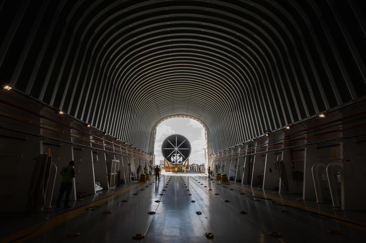 In this view from inside NASA’s Pegasus Barge, the 212-foot-long Space Launch System (SLS) rocket core stage pathfinder is being offloaded from the barge at Kennedy Space Center’s Launch Complex 39 turn basin wharf on Sept. 30, 2019. The Pegasus Barge made its first delivery to Kennedy in support of the agency's Artemis missions. The upgraded 310-foot-long barge arrived Sept. 27, 2019, ferrying the SLS core stage pathfinder, a full-scale mock-up of the rocket's core stage. It will be used by the Exploration Ground Systems Program and their contractor, Jacobs, to practice offloading, moving and stacking maneuvers, using important ground support equipment to train employees and certify all the equipment works properly. The pathfinder will stay at Kennedy for approximately one month before trekking back to NASA's Michoud Assembly Facility in Louisiana.