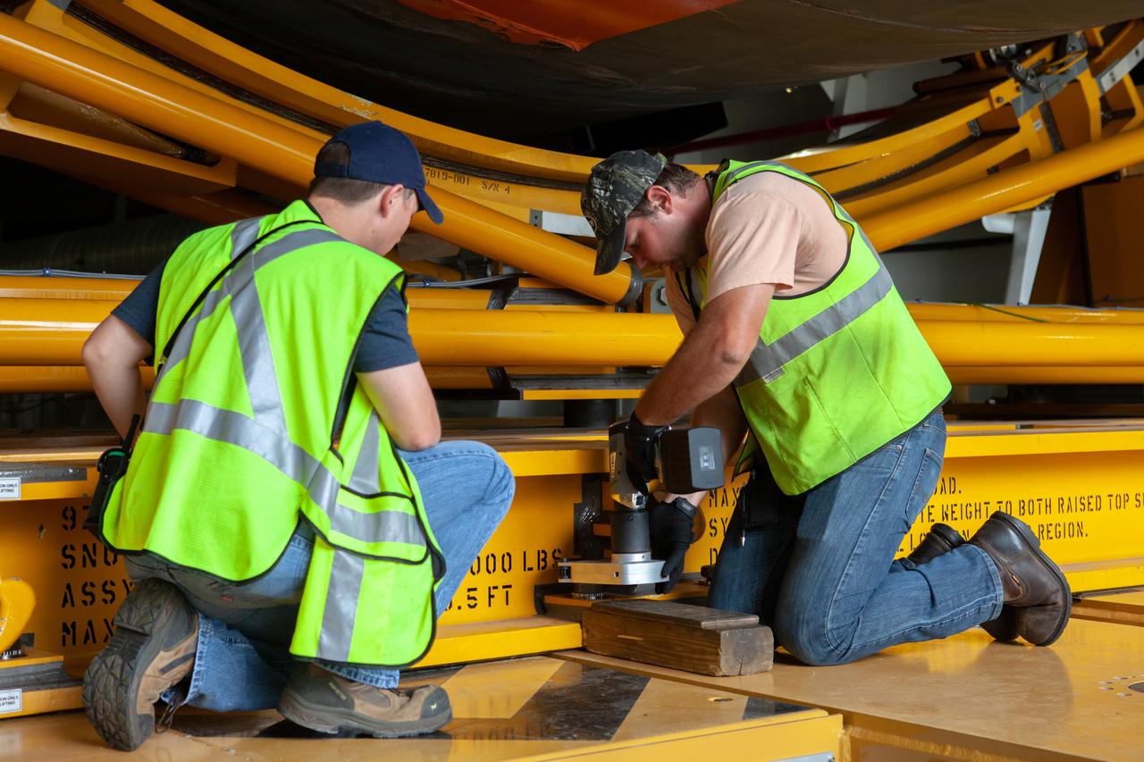 Jacobs TOSC Launch Vehicle Technical Operations technicians James Erdman, operator, and Nick Hall, observer prepare the transporter to begin offloading the 212-foot-long Space Launch System (SLS) rocket core stage pathfinder from NASA's Pegasus Barge at Kennedy Space Center’s Launch Complex 39 turn basin wharf on Oct. 1, 2019. The Pegasus Barge made its first delivery to Kennedy in support of the agency's Artemis missions. The upgraded 310-foot-long barge arrived Sept. 27, 2019, ferrying the SLS core stage pathfinder, a full-scale mock-up of the rocket's core stage. It will be used by Exploration Ground Systems and its contractor, Jacobs, to practice offloading, moving and stacking maneuvers, using important ground support equipment to train employees and certify all the equipment works properly. The pathfinder will stay at Kennedy for approximately one month before trekking back to NASA's Michoud Assembly Facility in Louisiana.