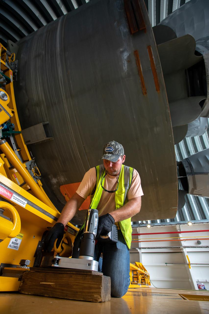 James Erdman, a Jacobs TOSC Launch Vehicle Technical Operations technician adjusts the transporter that carries the 212-foot-long Space Launch System (SLS) rocket core stage pathfinder for offloading from NASA's Pegasus Barge at Kennedy Space Center’s Launch Complex 39 turn basin wharf on Oct. 1, 2019. The Pegasus Barge made its first delivery to Kennedy in support of the agency's Artemis missions. The upgraded 310-foot-long barge arrived Sept. 27, 2019, ferrying the SLS core stage pathfinder, a full-scale mock-up of the rocket's core stage. It will be used by Exploration Ground Systems and its contractor, Jacobs, to practice offloading, moving and stacking maneuvers, using important ground support equipment to train employees and certify all the equipment works properly. The pathfinder will stay at Kennedy for approximately one month before trekking back to NASA's Michoud Assembly Facility in Louisiana.