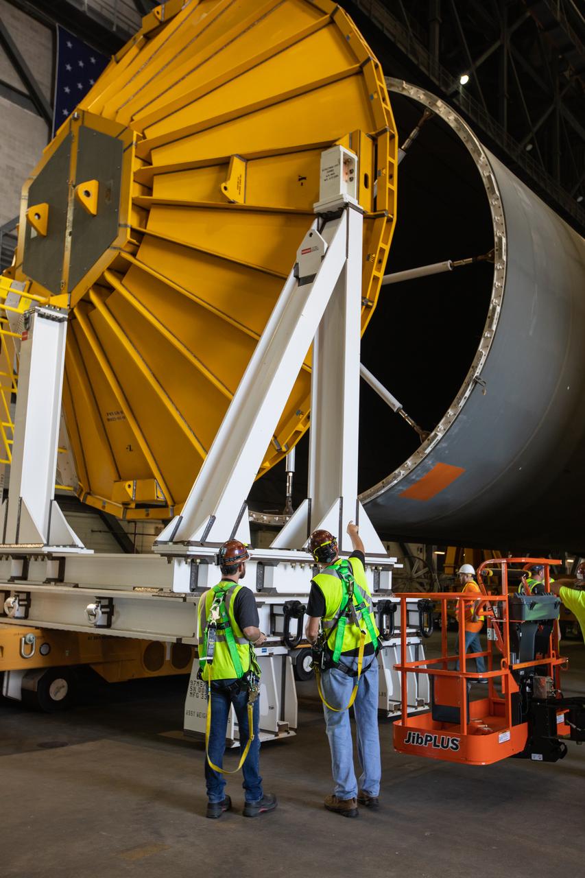 Inside the Vehicle Assembly Building at NASA’s Kennedy Space Center in Florida, NASA and Jacobs TOSC workers monitor the progress as a cover, called the spider, is attached to the top of the Space Launch System (SLS) Core Stage pathfinder on Oct. 3, 2019. With the spider secured in place, a crane will be attached to it to lift the pathfinder into the vertical position. The 212-foot-long core stage pathfinder arrived in NASA's Pegasus Barge at Kennedy’s Launch Complex 39 turn basin wharf on Sept. 27, 2019. The Pegasus Barge made its first delivery to Kennedy in support of the agency's Artemis missions. The upgraded 310-foot-long barge arrived, ferrying the SLS core stage pathfinder, a full-scale mock-up of the rocket's core stage. It will be used by Exploration Ground Systems and its contractor, Jacobs, to practice offloading, moving and stacking maneuvers, using important ground support equipment to train employees and certify all the equipment works properly. The pathfinder will stay at Kennedy for approximately one month before trekking back to NASA's Michoud Assembly Facility in Louisiana.