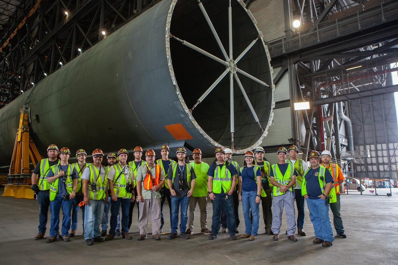 Inside the Vehicle Assembly Building at NASA’s Kennedy Space Center in Florida, a group of NASA and Jacobs TOSC workers gather near the Space Launch System (SLS) Core Stage pathfinder on Oct. 3, 2019. Operations will begin to attach a cover, called a spider, to the top of the Core Stage pathfinder. With the spider secured in place, a crane will be attached to it to lift the pathfinder into the vertical position. The 212-foot-long core stage pathfinder arrived in NASA's Pegasus Barge at Kennedy’s Launch Complex 39 turn basin wharf on Sept. 27, 2019. The Pegasus Barge made its first delivery to Kennedy in support of the agency's Artemis missions. The upgraded 310-foot-long barge arrived, ferrying the SLS core stage pathfinder, a full-scale mock-up of the rocket's core stage. It will be used by Exploration Ground Systems and its contractor, Jacobs, to practice offloading, moving and stacking maneuvers, using important ground support equipment to train employees and certify all the equipment works properly. The pathfinder will stay at Kennedy for approximately one month before trekking back to NASA's Michoud Assembly Facility in Louisiana.