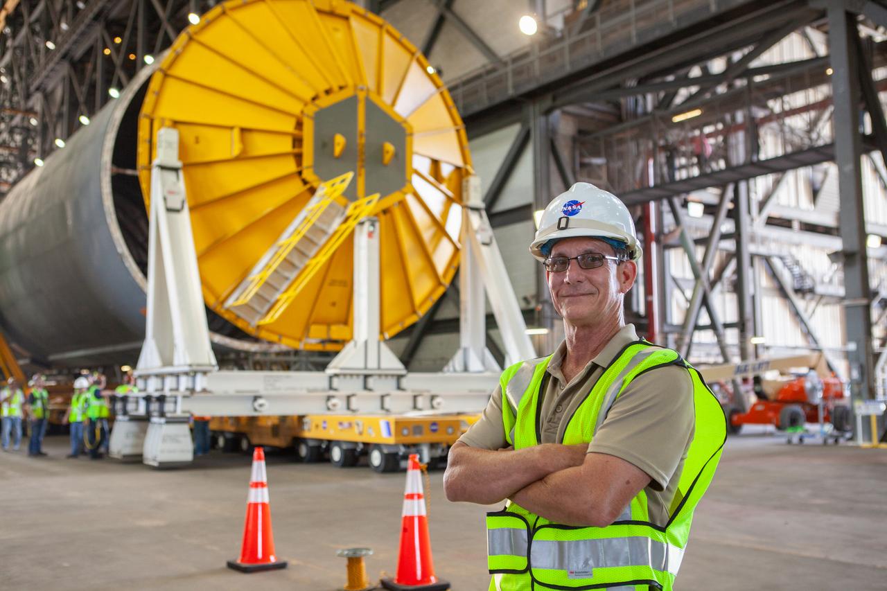 Jim Bolton, Core Stage Element Operations manager in Exploration Ground Systems (EGS), is at the north end of the transfer aisle in the Vehicle Assembly Building at NASA’s Kennedy Space Center in Florida on Oct. 3, 2019. Behind him is the Space Launch System Core Stage pathfinder. A cover, called a spider, is being attached to the top of the pathfinder. With the spider secured in place, a crane will be attached to it to lift the pathfinder into the vertical position. The 212-foot-long core stage pathfinder arrived aboard NASA's Pegasus Barge at Kennedy’s Launch Complex 39 turn basin wharf on Sept. 27, 2019. The Pegasus Barge made its first delivery to Kennedy in support of the agency's Artemis missions. The upgraded 310-foot-long barge arrived, ferrying the SLS core stage pathfinder, a full-scale mock-up of the rocket's core stage. It will be used by EGS and its contractor, Jacobs, to practice offloading, moving and stacking maneuvers, using important ground support equipment to train employees and certify all the equipment works properly. The pathfinder will stay at Kennedy for approximately one month before trekking back to NASA's Michoud Assembly Facility in Louisiana.