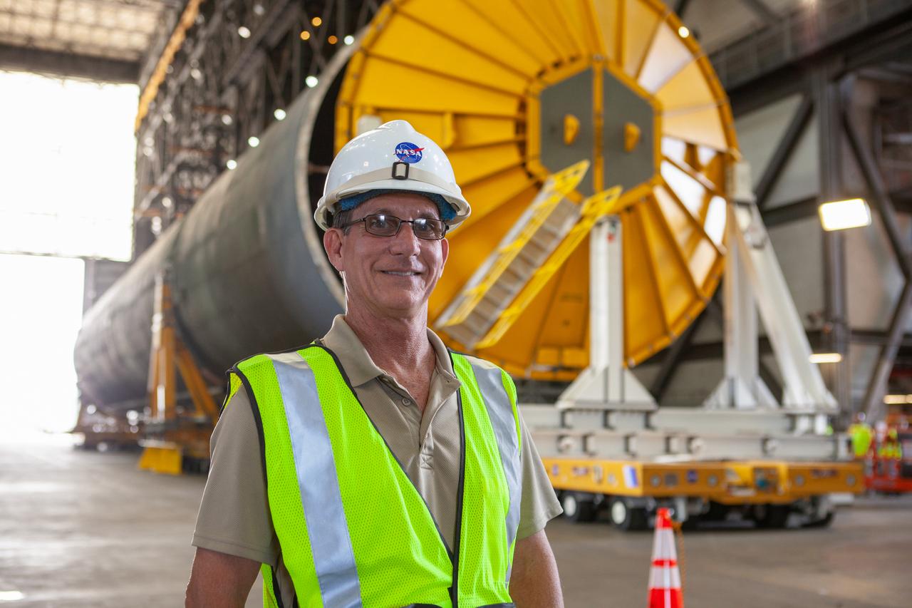 Jim Bolton, Core Stage Element Operations manager in Exploration Ground Systems (EGS), is at the north end of the transfer aisle in the Vehicle Assembly Building at NASA’s Kennedy Space Center in Florida on Oct. 3, 2019. Behind him is the Space Launch System Core Stage pathfinder. A cover, called a spider, is being attached to the top of the pathfinder. With the spider secured in place, a crane will be attached to it to lift the pathfinder into the vertical position. The 212-foot-long core stage pathfinder arrived aboard NASA's Pegasus Barge at Kennedy’s Launch Complex 39 turn basin wharf on Sept. 27, 2019. The Pegasus Barge made its first delivery to Kennedy in support of the agency's Artemis missions. The upgraded 310-foot-long barge arrived, ferrying the SLS core stage pathfinder, a full-scale mock-up of the rocket's core stage. It will be used by EGS and its contractor, Jacobs, to practice offloading, moving and stacking maneuvers, using important ground support equipment to train employees and certify all the equipment works properly. The pathfinder will stay at Kennedy for approximately one month before trekking back to NASA's Michoud Assembly Facility in Louisiana.