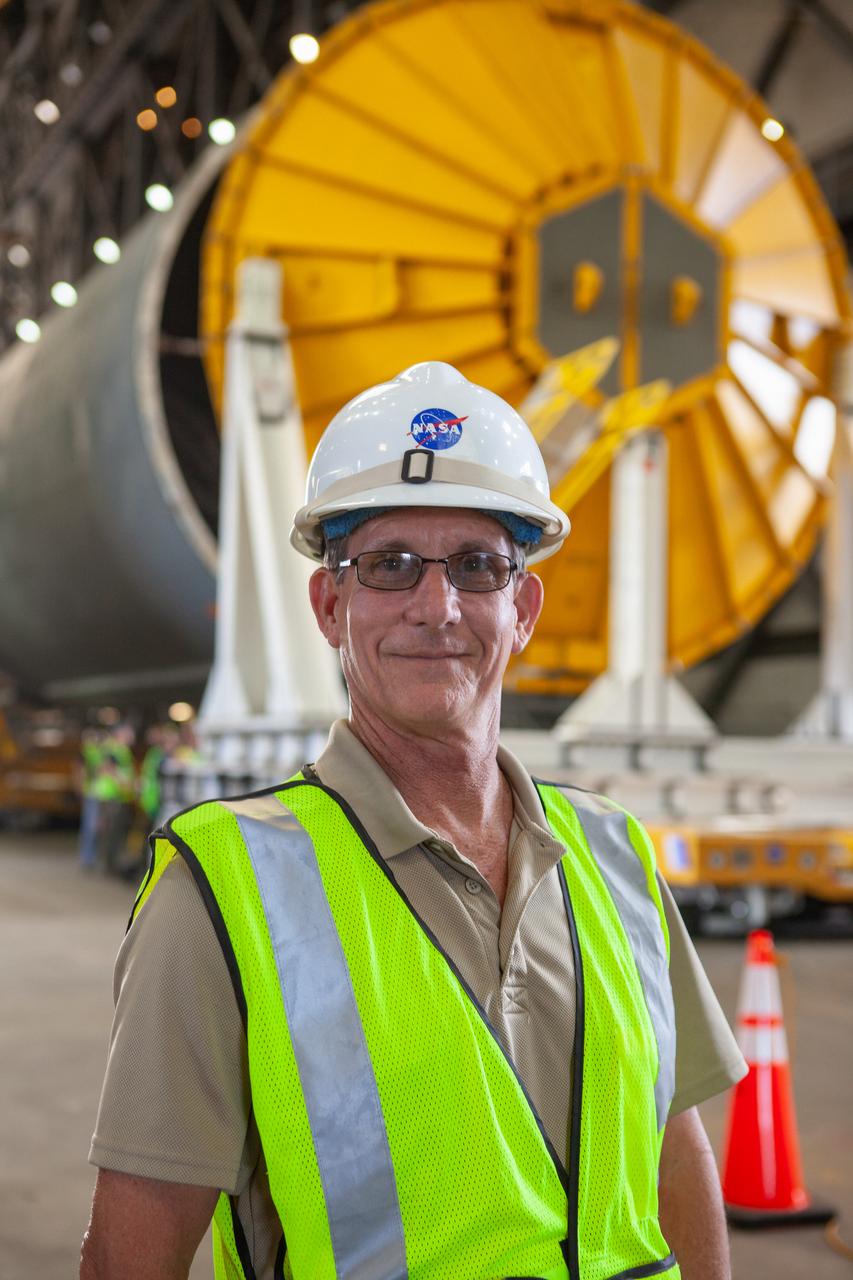Jim Bolton, Core Stage Element Operations manager in Exploration Ground Systems (EGS), is at the north end of the transfer aisle in the Vehicle Assembly Building at NASA’s Kennedy Space Center in Florida on Oct. 3, 2019. Behind him is the Space Launch System Core Stage pathfinder. A cover, called a spider, is being attached to the top of the pathfinder. With the spider secured in place, a crane will be attached to it to lift the pathfinder into the vertical position. The 212-foot-long core stage pathfinder arrived aboard NASA's Pegasus Barge at Kennedy’s Launch Complex 39 turn basin wharf on Sept. 27, 2019. The Pegasus Barge made its first delivery to Kennedy in support of the agency's Artemis missions. The upgraded 310-foot-long barge arrived, ferrying the SLS core stage pathfinder, a full-scale mock-up of the rocket's core stage. It will be used by EGS and its contractor, Jacobs, to practice offloading, moving and stacking maneuvers, using important ground support equipment to train employees and certify all the equipment works properly. The pathfinder will stay at Kennedy for approximately one month before trekking back to NASA's Michoud Assembly Facility in Louisiana.
