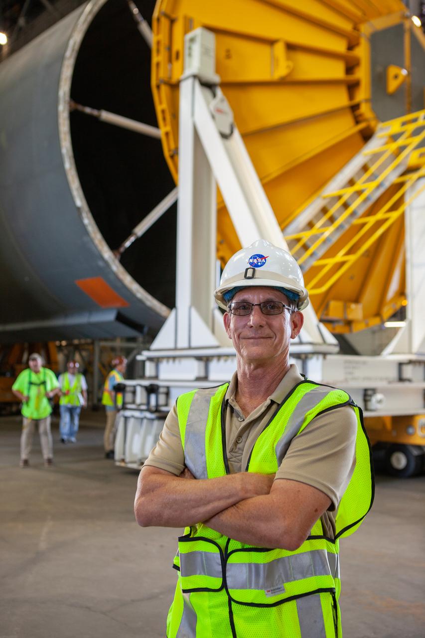 Jim Bolton, Core Stage Element Operations manager in Exploration Ground Systems (EGS), is at the north end of the transfer aisle in the Vehicle Assembly Building at NASA’s Kennedy Space Center in Florida on Oct. 3, 2019. Behind him is the Space Launch System Core Stage pathfinder. A cover, called a spider, is being attached to the top of the pathfinder. With the spider secured in place, a crane will be attached to it to lift the pathfinder into the vertical position. The 212-foot-long core stage pathfinder arrived aboard NASA's Pegasus Barge at Kennedy’s Launch Complex 39 turn basin wharf on Sept. 27, 2019. The Pegasus Barge made its first delivery to Kennedy in support of the agency's Artemis missions. The upgraded 310-foot-long barge arrived, ferrying the SLS core stage pathfinder, a full-scale mock-up of the rocket's core stage. It will be used by EGS and its contractor, Jacobs, to practice offloading, moving and stacking maneuvers, using important ground support equipment to train employees and certify all the equipment works properly. The pathfinder will stay at Kennedy for approximately one month before trekking back to NASA's Michoud Assembly Facility in Louisiana.