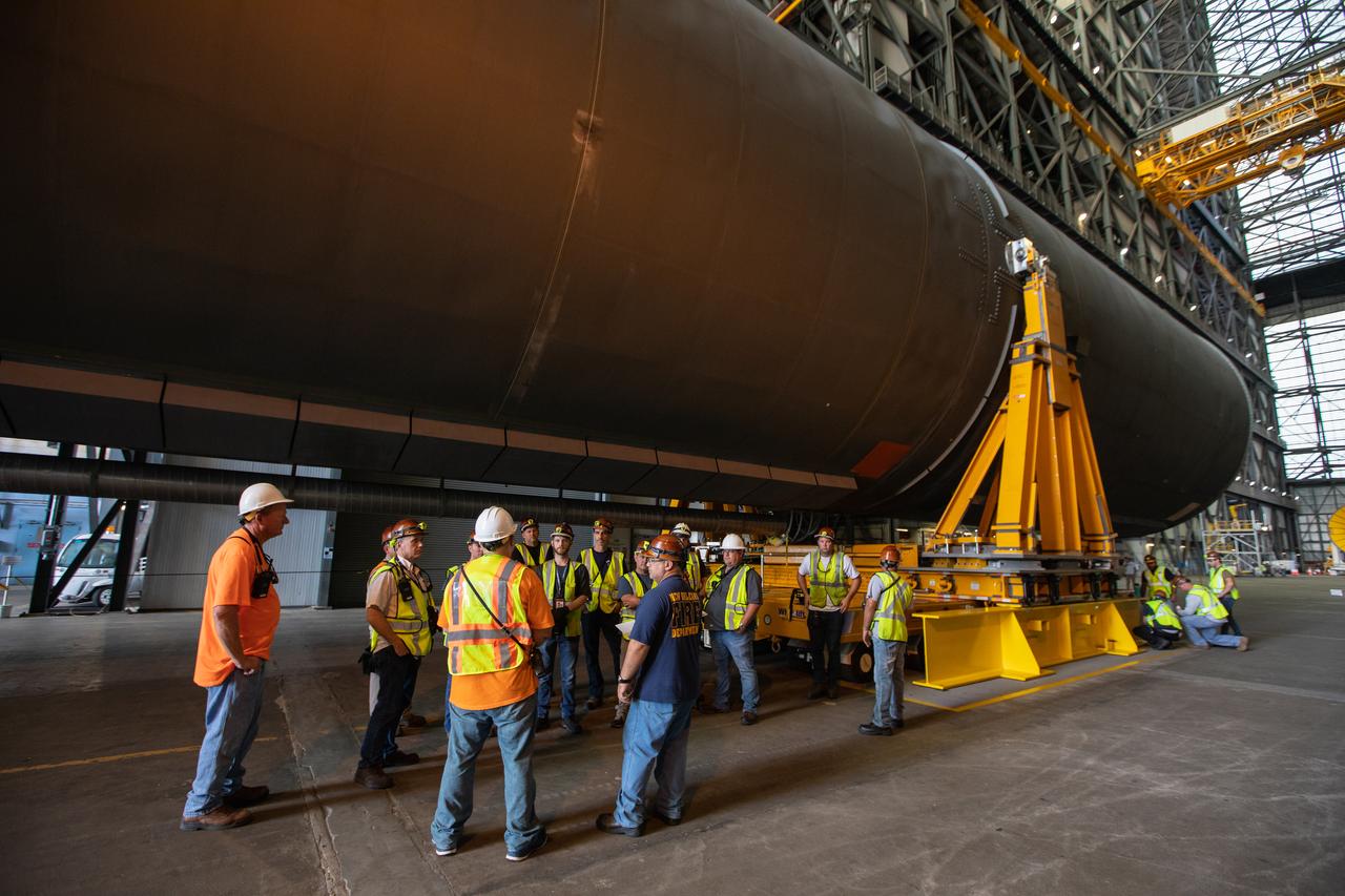 Preparations are underway to move the Space Launch System Core Stage pathfinder to the north end of the transfer aisle inside the Vehicle Assembly Building at NASA’s Kennedy Space Center in Florida on Oct. 3, 2019. A cover, called a spider, will be attached to the top of the pathfinder. With the spider secured in place, a crane will be attached to it to lift the pathfinder into the vertical position. The 212-foot-long core stage pathfinder arrived in NASA's Pegasus Barge at Kennedy’s Launch Complex 39 turn basin wharf on Sept. 27, 2019. The Pegasus Barge made its first delivery to Kennedy in support of the agency's Artemis missions. The upgraded 310-foot-long barge arrived, ferrying the SLS core stage pathfinder, a full-scale mock-up of the rocket's core stage. It will be used by Exploration Ground Systems and its contractor, Jacobs, to practice offloading, moving and stacking maneuvers, using important ground support equipment to train employees and certify all the equipment works properly. The pathfinder will stay at Kennedy for approximately one month before trekking back to NASA's Michoud Assembly Facility in Louisiana.