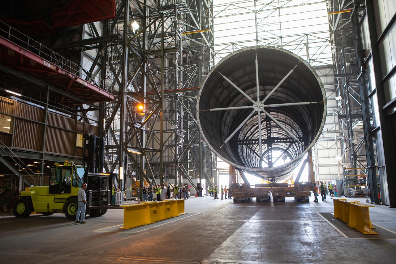 The Space Launch System Core Stage pathfinder is being moved to the north end of the transfer aisle inside the Vehicle Assembly Building at NASA’s Kennedy Space Center in Florida on Oct. 3, 2019. A cover, called a spider, will be attached to the top of the pathfinder. With the spider secured in place, a crane will be attached to it to lift the pathfinder into the vertical position. The 212-foot-long core stage pathfinder arrived in NASA's Pegasus Barge at Kennedy’s Launch Complex 39 turn basin wharf on Sept. 27, 2019. The Pegasus Barge made its first delivery to Kennedy in support of the agency's Artemis missions. The upgraded 310-foot-long barge arrived, ferrying the SLS core stage pathfinder, a full-scale mock-up of the rocket's core stage. It will be used by Exploration Ground Systems and its contractor, Jacobs, to practice offloading, moving and stacking maneuvers, using important ground support equipment to train employees and certify all the equipment works properly. The pathfinder will stay at Kennedy for approximately one month before trekking back to NASA's Michoud Assembly Facility in Louisiana.